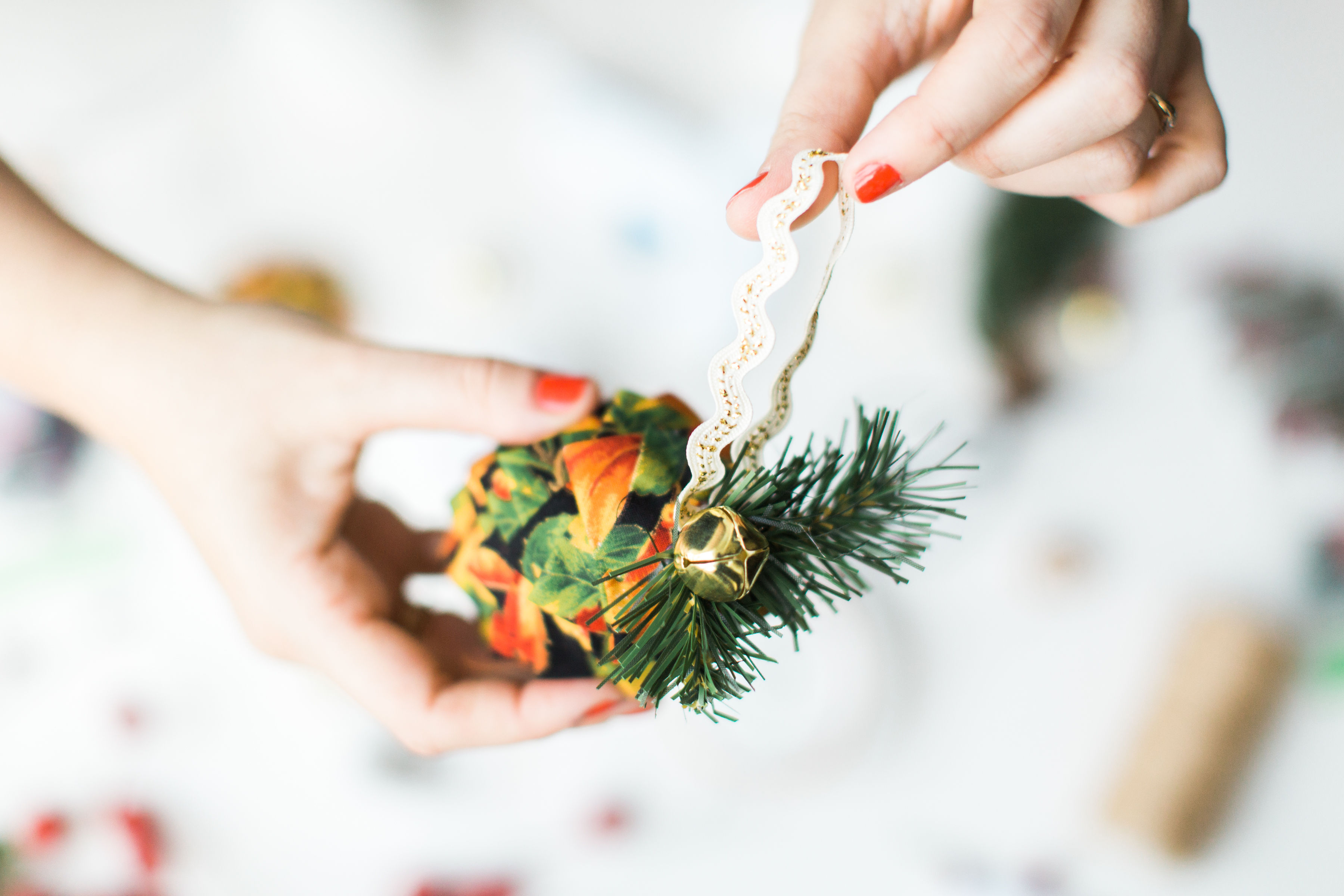 Looking for a fun Christmas craft to make this holiday season? DIY folded fabric pinecones make the prettiest ornaments, are perfect as gift toppers, and use up leftover fabric scraps - no sewing required. Click through for the details. #diyfabricpinecones #christmascraft #holidaycraft #holidaydiy #christmasdiy #nosew | glitterinc.com | @glitterinc