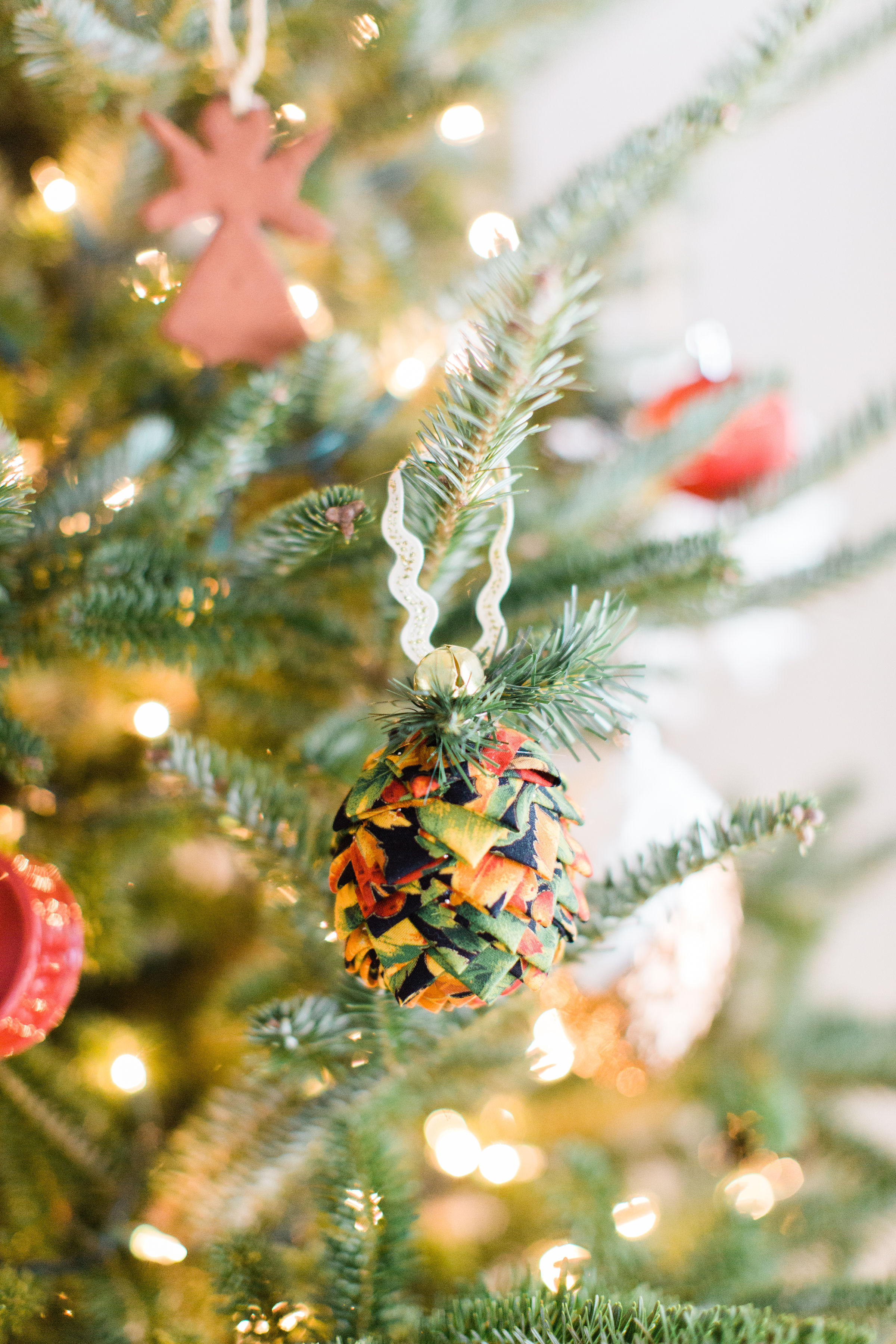 Looking for a fun Christmas craft to make this holiday season? DIY folded fabric pinecones make the prettiest ornaments, are perfect as gift toppers, and use up leftover fabric scraps - no sewing required. Click through for the details. #diyfabricpinecones #christmascraft #holidaycraft #christmasdiy #nosew | glitterinc.com | @glitterinc