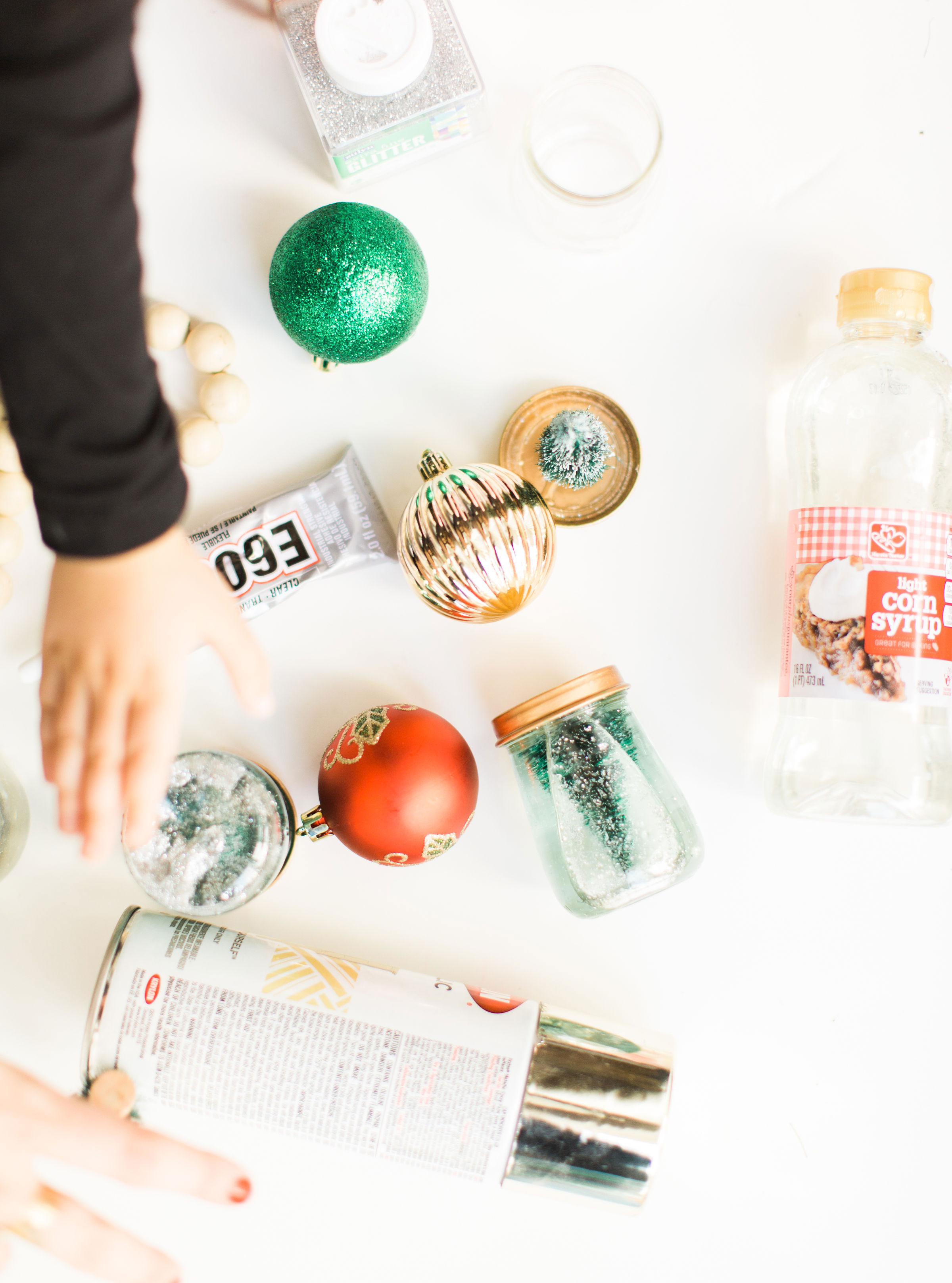 Glitter DIY snow globes are fun to make, are a great craft to do with kids, and double as a calm down sensory bottle for a little quiet time on days when the whole family is going a little stir crazy! Click through for the details. #kidsdiy #kidscraft #diysnowglobes #howtomakesnowglobes #sensorybottles #sensoryglobes #toddlercraft #wintercraft #christmas #christmasdiy #christmascraft | glitterinc.com | @glitterinc