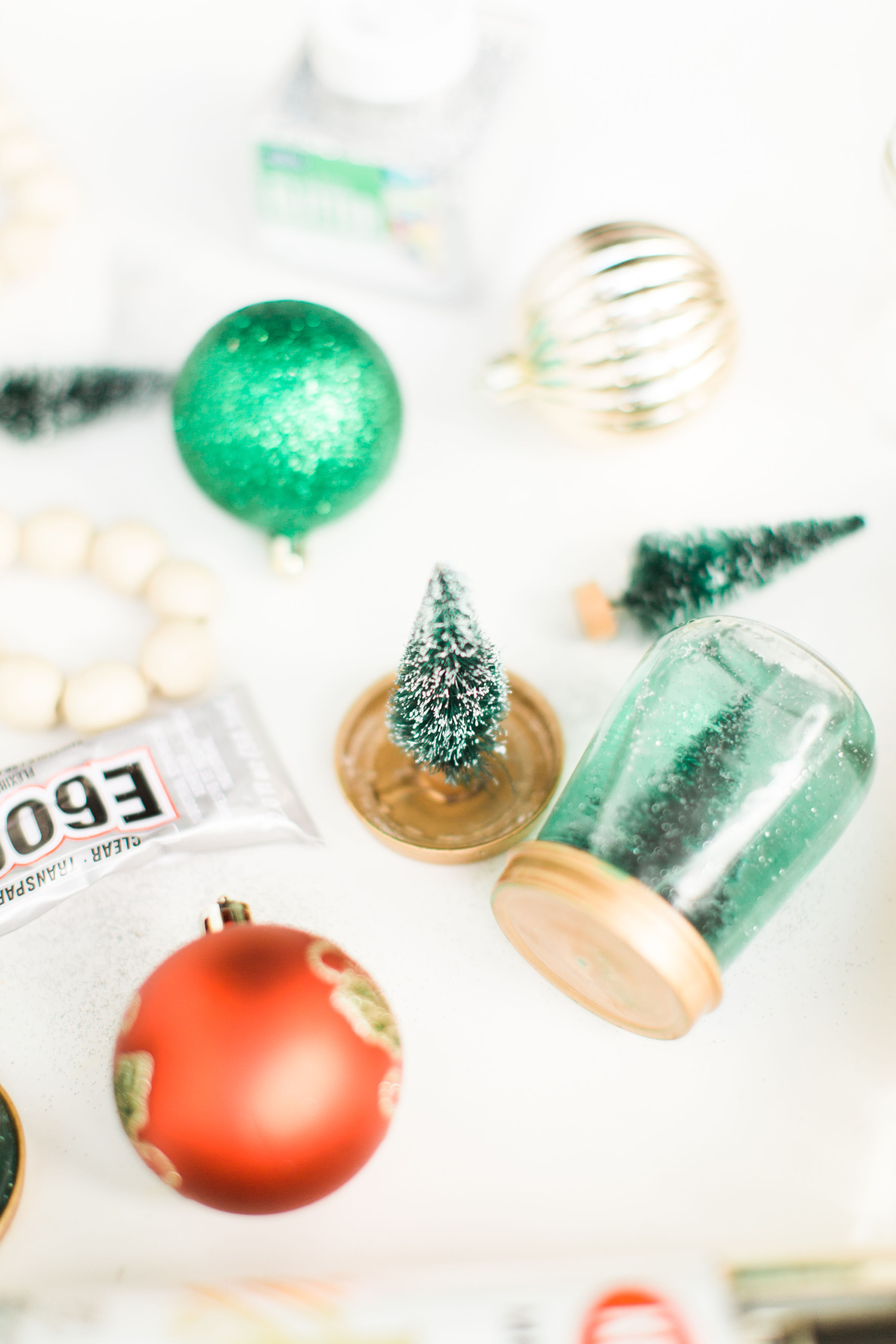 Glitter DIY snow globes are fun to make, are a great craft to do with kids, and double as a calm down sensory bottle for a little quiet time on days when the whole family is going a little stir crazy! Click through for the details. #kidsdiy #kidscraft #diysnowglobes #howtomakesnowglobes #sensorybottles #sensoryglobes #toddlercraft #wintercraft #christmas #christmasdiy #christmascraft | glitterinc.com | @glitterinc