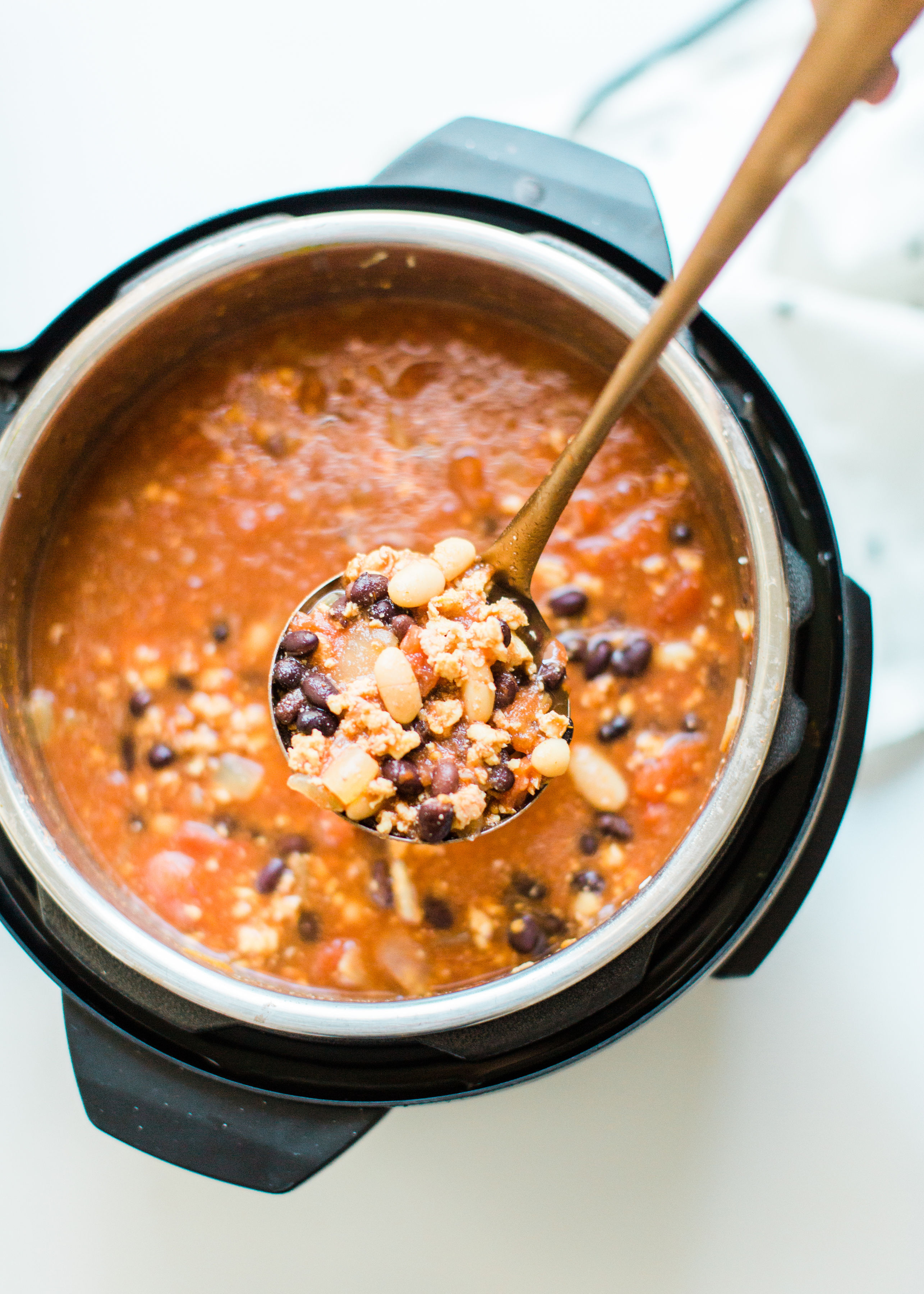 This easy and delicious ground chicken chili all comes together in an Instant Pot or crockpot. Serve this made ahead chili with yummy toppings and cornbread and enjoy an incredible, hearty, healthy, and simple meal. Click through for the recipe. | glitterinc.com | @glitterinc