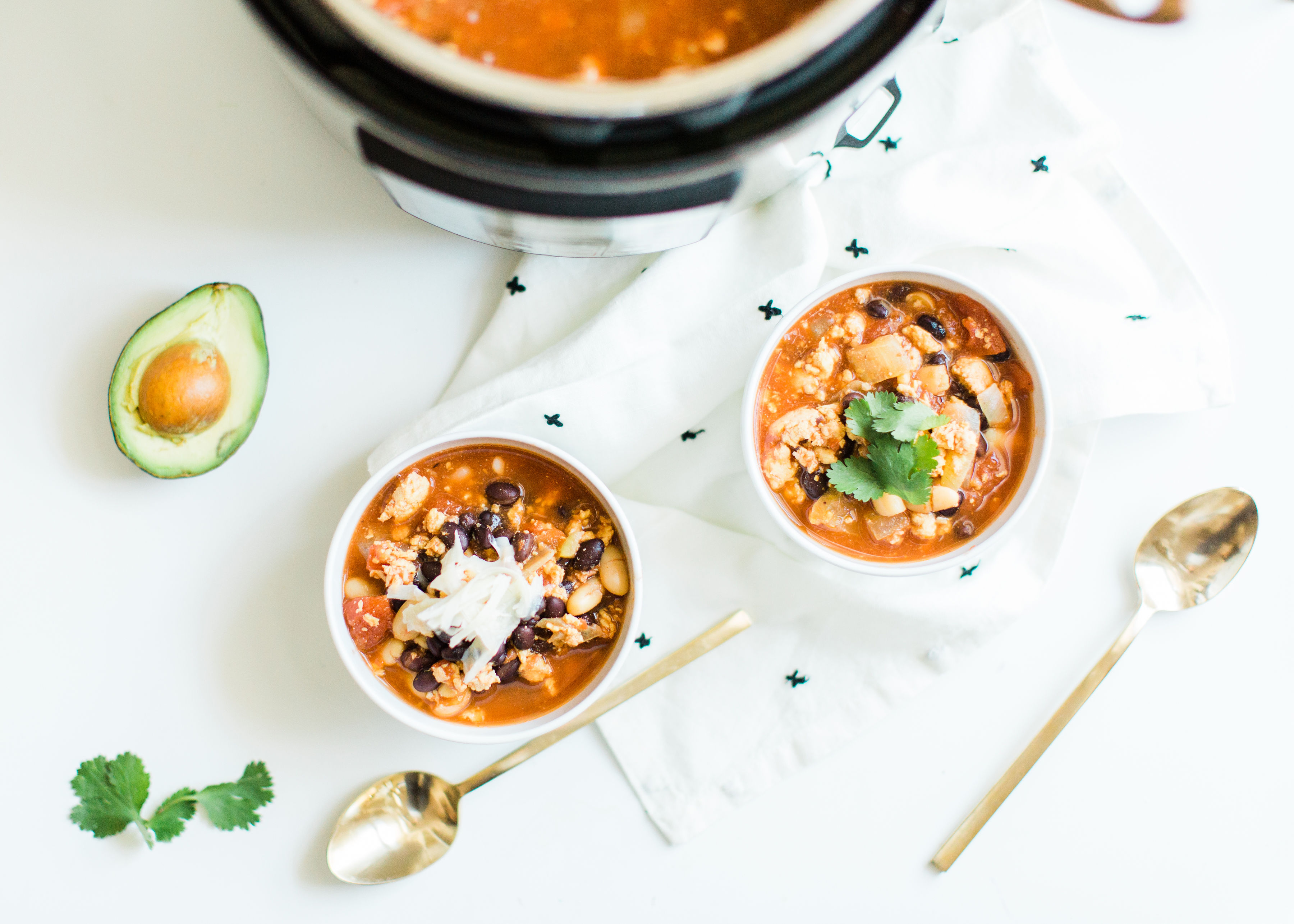 This easy and delicious ground chicken chili all comes together in an Instant Pot or crockpot. Serve this made ahead chili with yummy toppings and cornbread and enjoy an incredible, hearty, healthy, and simple meal. Click through for the recipe. | glitterinc.com | @glitterinc