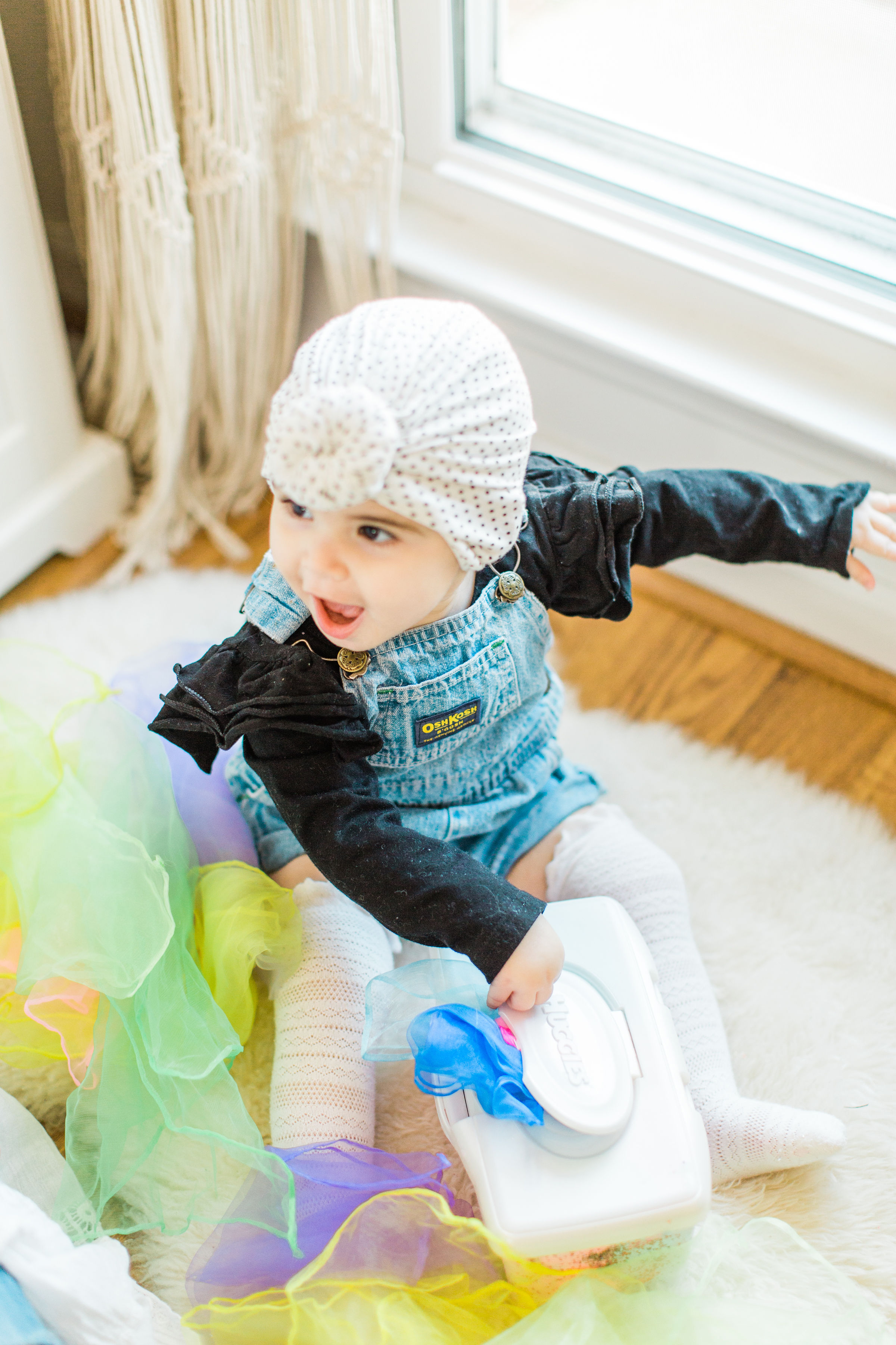 Looking for a fun activity to do with your baby? Make an easy, magic sensory toy using an empty wipes container and inexpensive colorful scarves. | Click through for the DIY. | glitterinc.com | @glitterinc