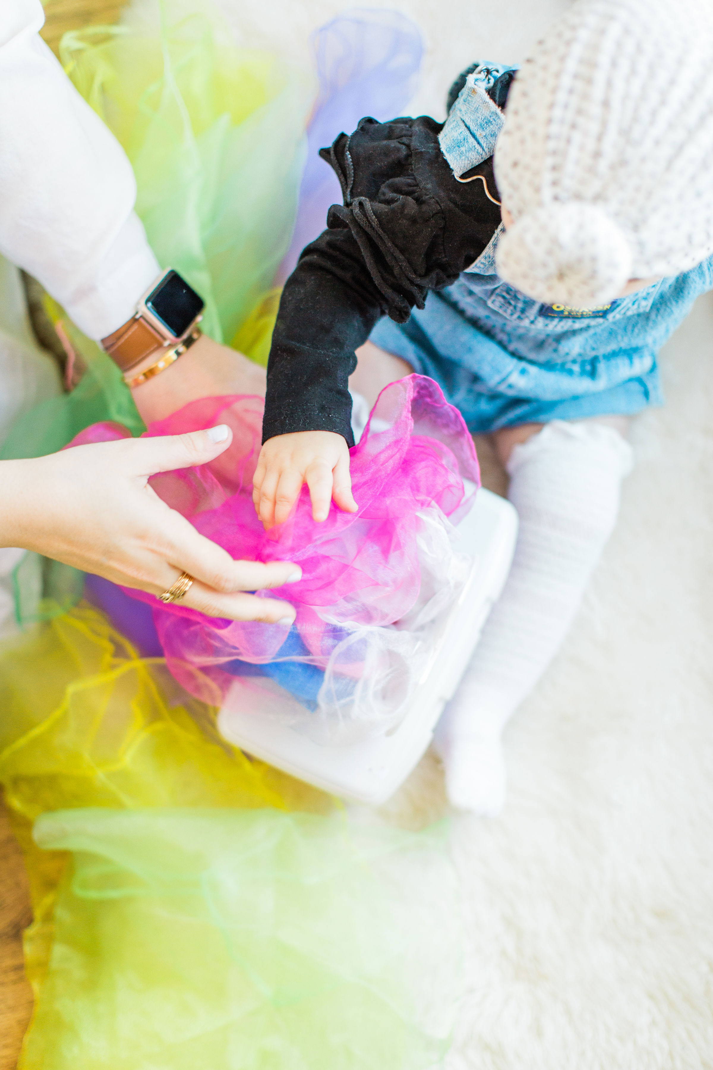 Looking for a fun activity to do with your baby? Make an easy, magic sensory toy using an empty wipes container and inexpensive colorful scarves.