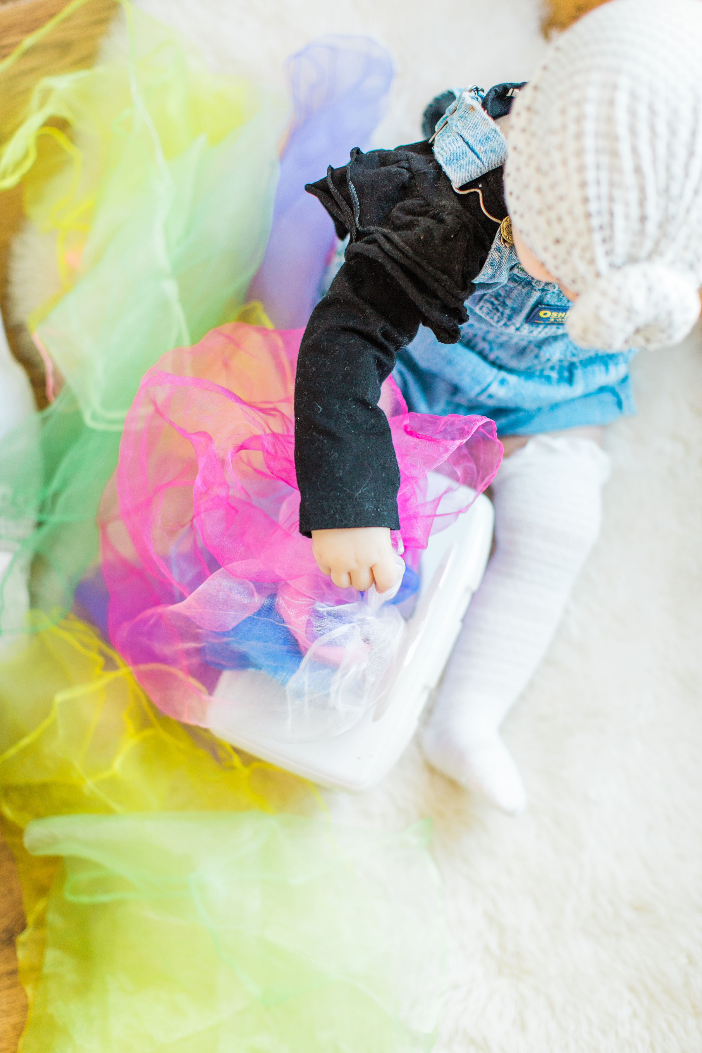 Looking for a fun activity to do with your baby? Make an easy, magic sensory toy using an empty wipes container and inexpensive colorful scarves. | Click through for the DIY. | glitterinc.com | @glitterinc