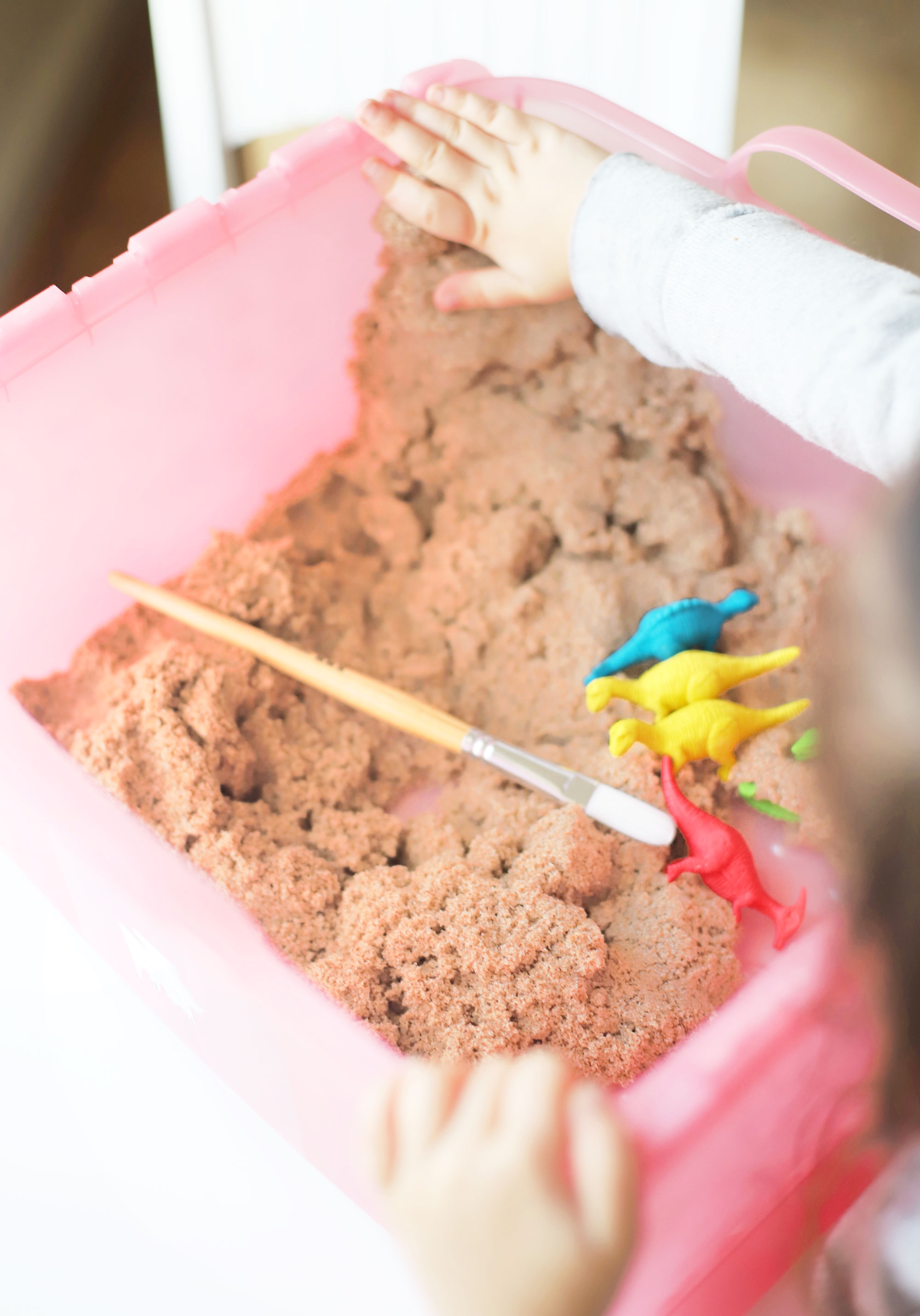 Create your own DIY kinetic sand dinosaur dig. This kids activity is an awesome, mostly mess-free way to dig into sensory play, all in one convenient bin.