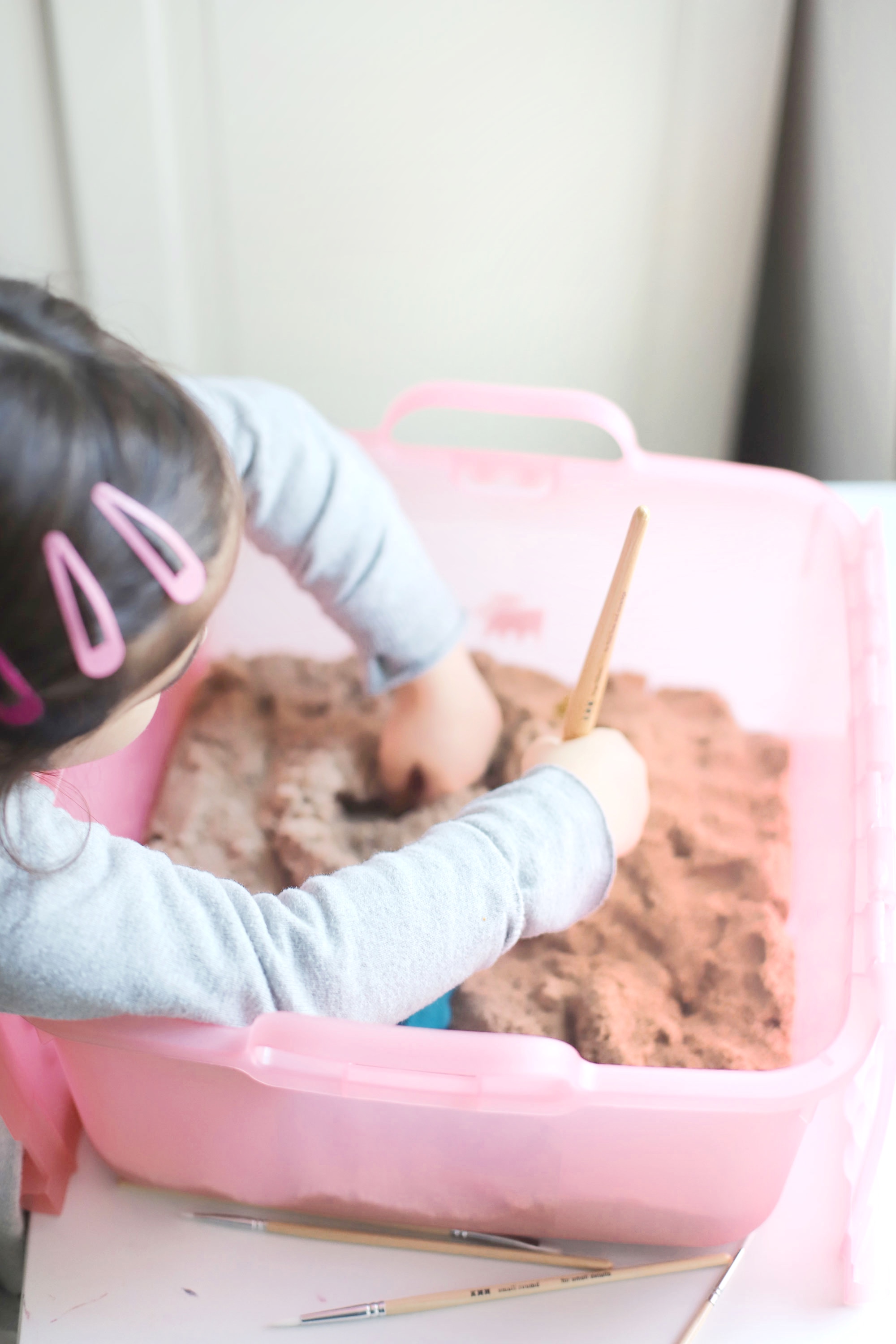 Create your own DIY kinetic sand dinosaur dig. This kids activity is an awesome, mostly mess-free way to dig into sensory play, all in one convenient bin