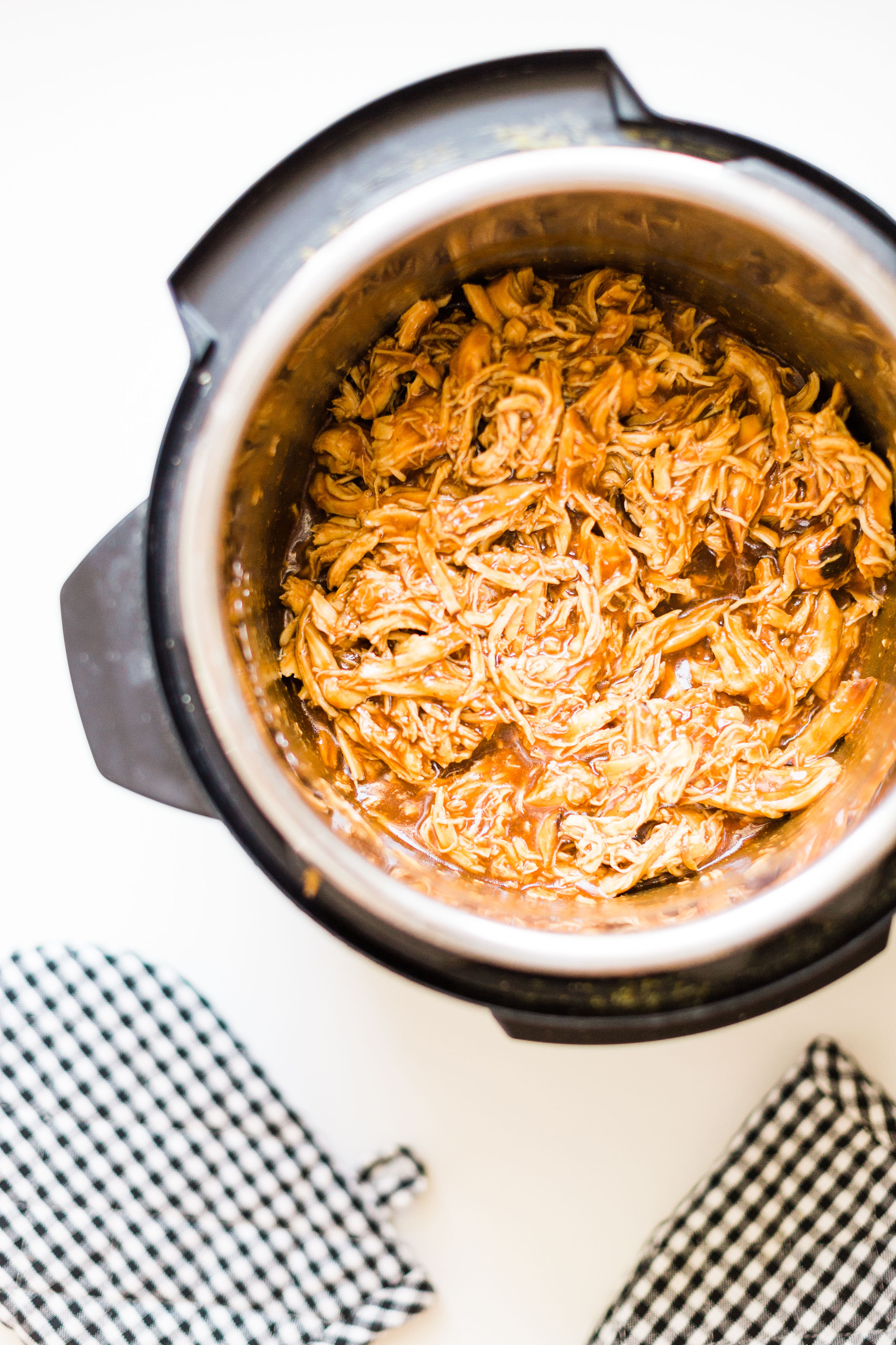 Skip the hot grill and make delicious barbecue pulled chicken in your slow cooker! Just throw a few ingredients right in the pot and let your crock pot or instant pot do the rest. Yum! Click through for the BBQ recipe. 