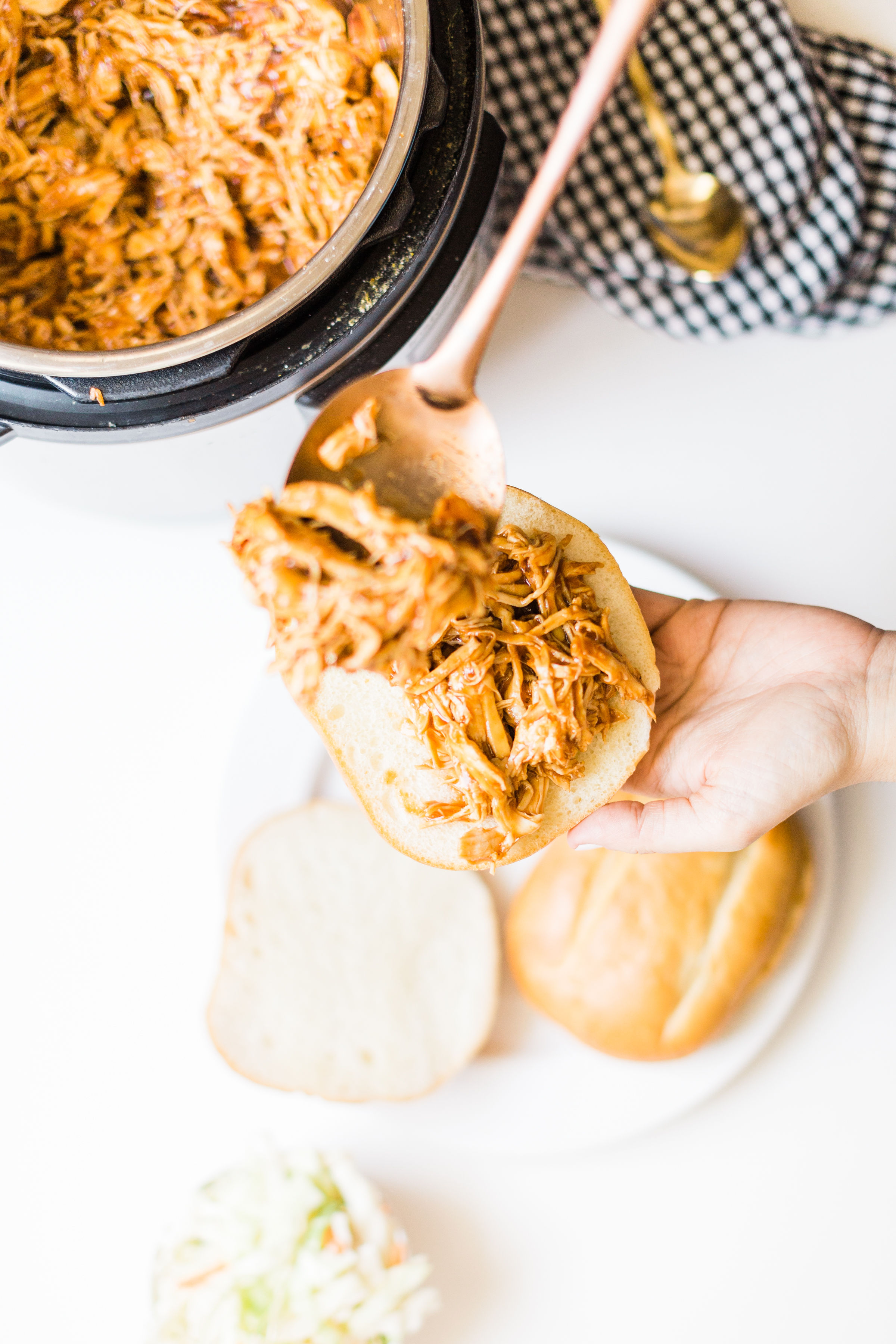Skip the hot grill and make delicious barbecue pulled chicken in your slow cooker! Just throw a few ingredients right in the pot and let your crock pot or instant pot do the rest. Yum! Click through for the BBQ recipe. | glitterinc.com | @glitterinc