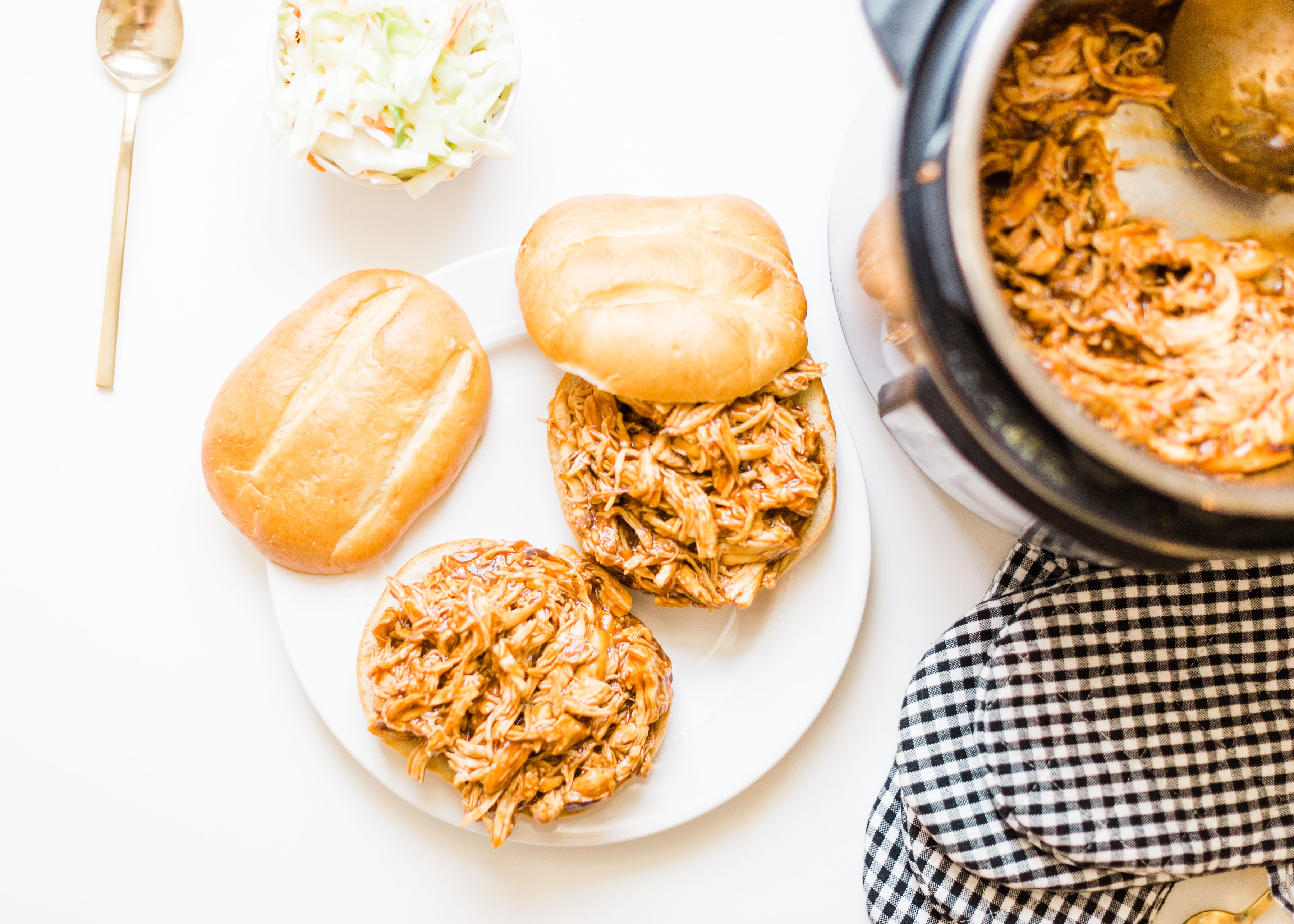 Skip the hot grill and make delicious barbecue pulled chicken in your slow cooker! Just throw a few ingredients right in the pot and let your crock pot or instant pot do the rest. Yum! Click through for the BBQ recipe. | glitterinc.com | @glitterinc