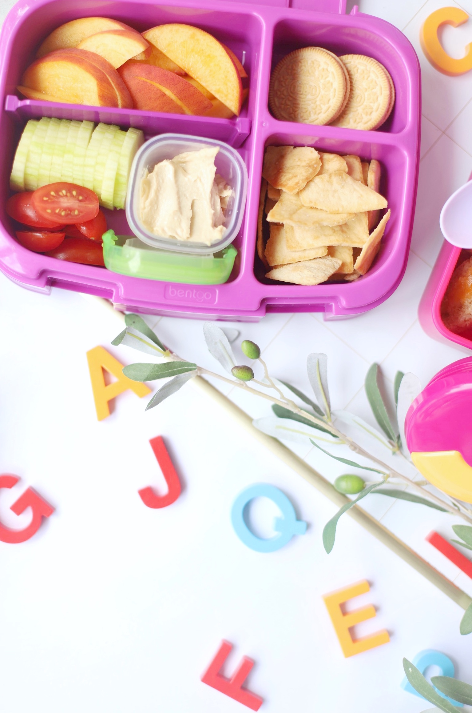 a lunch kit with crackers and tomatoes and apples