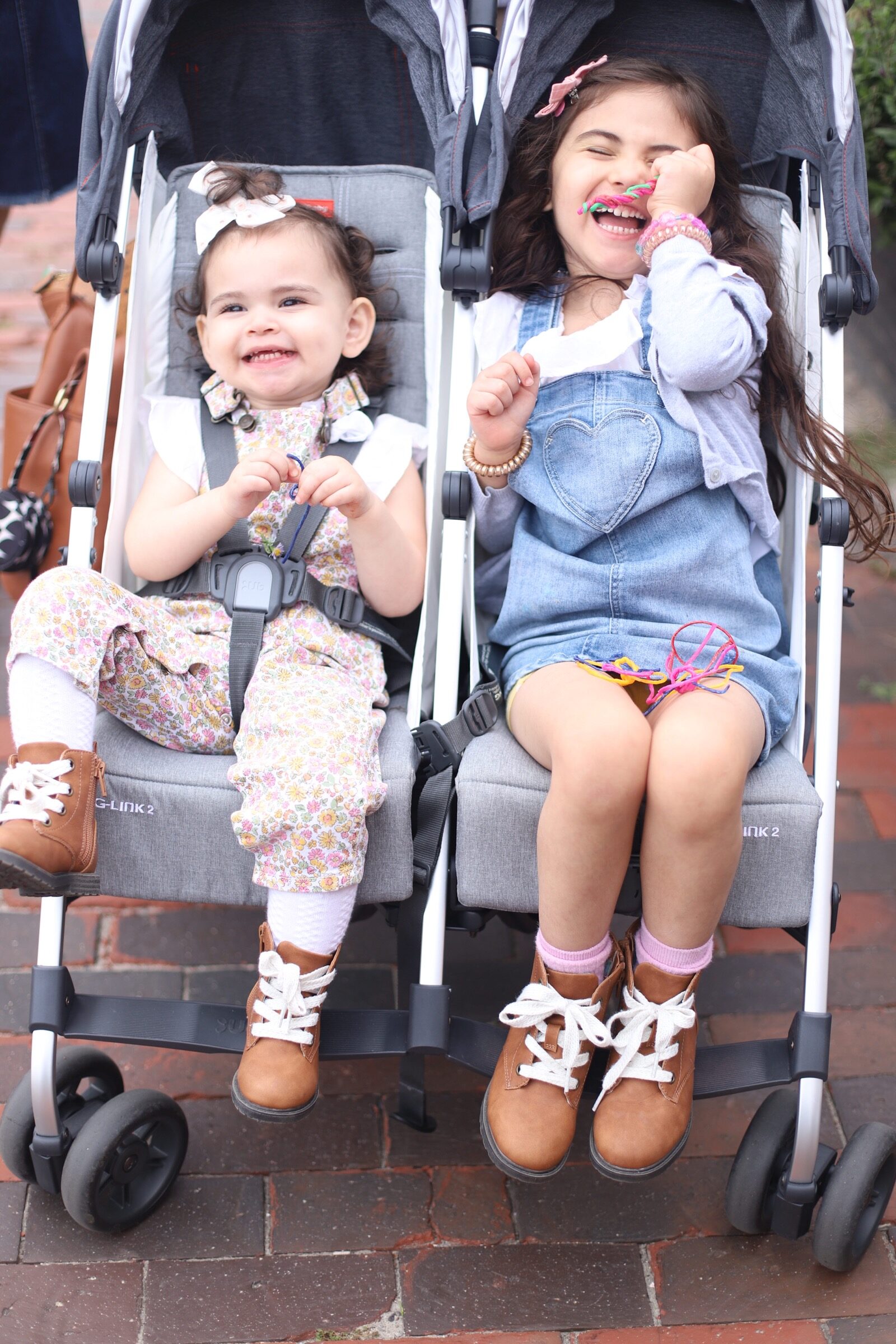 two kids laughing sitting in a stroller