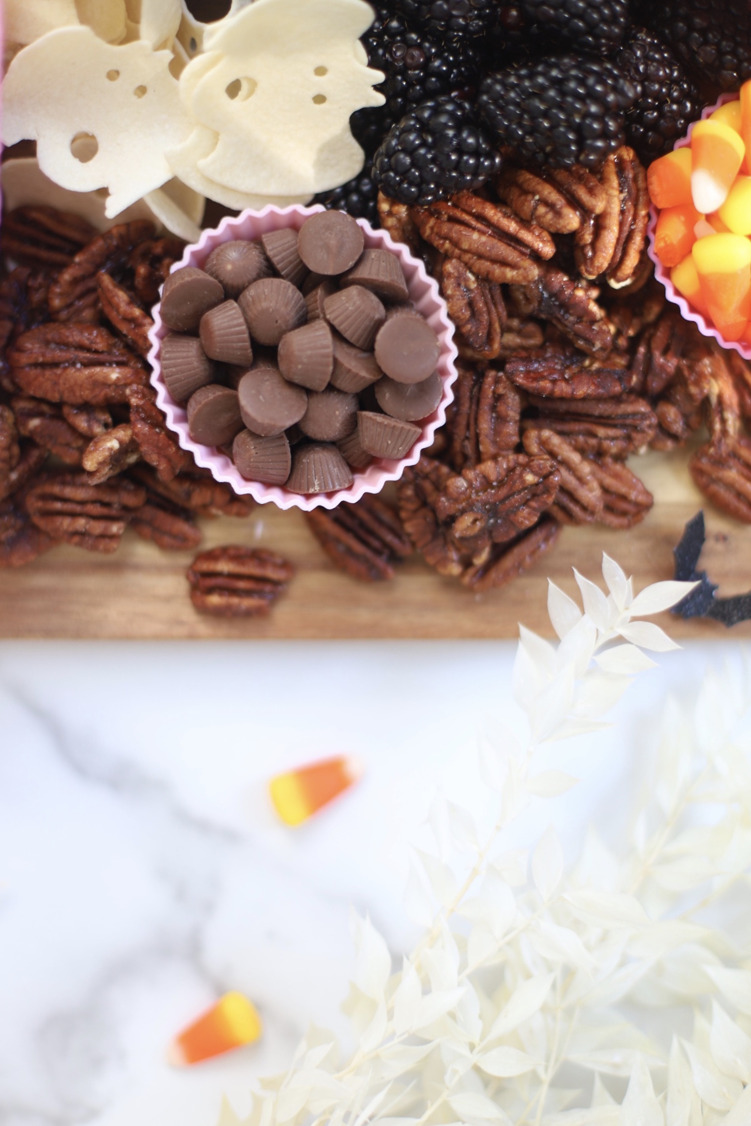 Serve a beautifully spooky Halloween charcuterie board chock full of snacks the whole family will love! This frightfully delicious snack board is perfect for Halloween celebrations, a no-fuss dinner after a night of trick-or-treating, even a festive afternoon snack throughout the month of October. Happy snacking! | glitterinc.com | @glitterinc