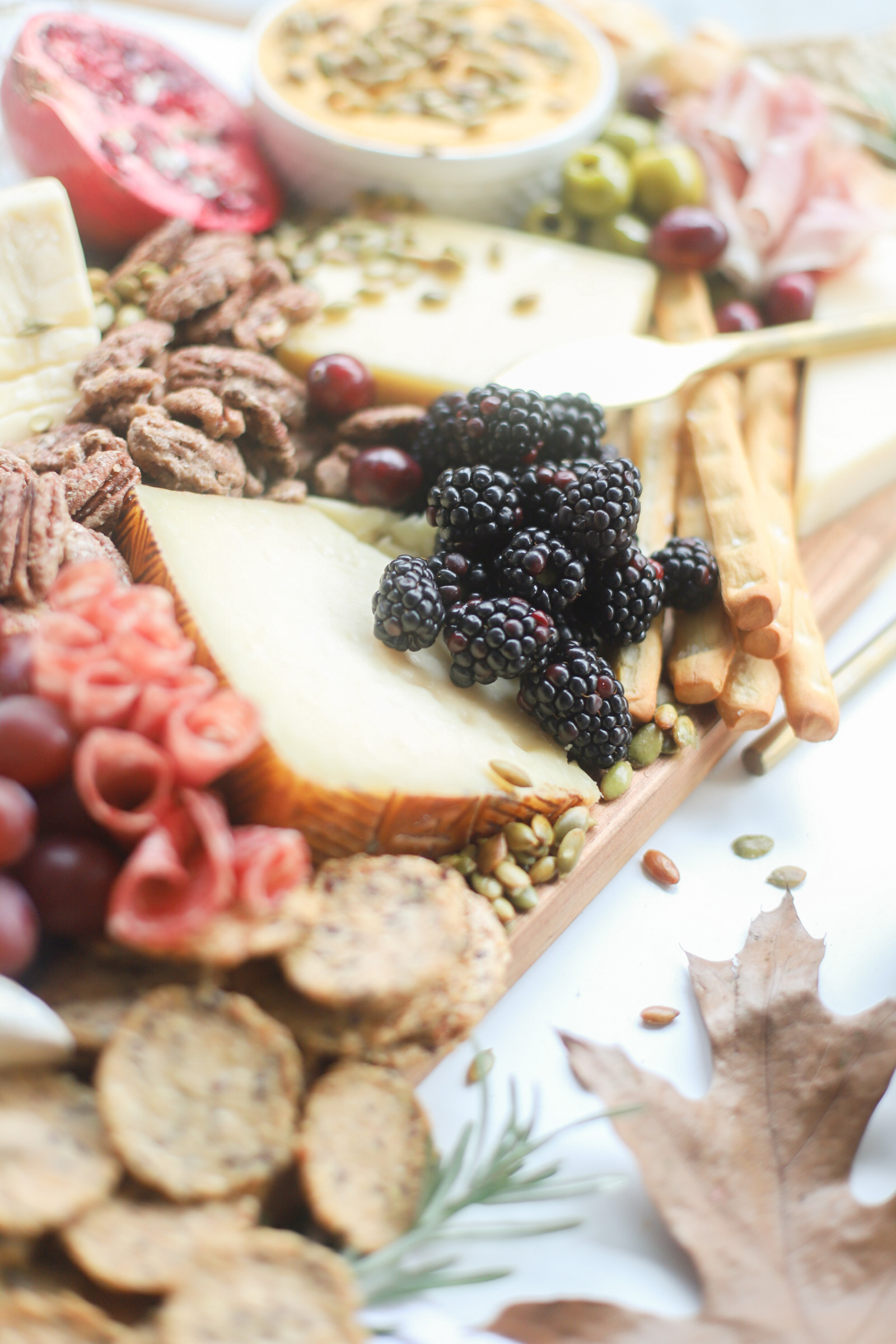 Putting together a big, beautiful charcuterie board is easier than you think. Make this impressive Thanksgiving cheese board for the fall holiday this year and seriously wow all of your guests! | glitterinc.com | @glitterinc