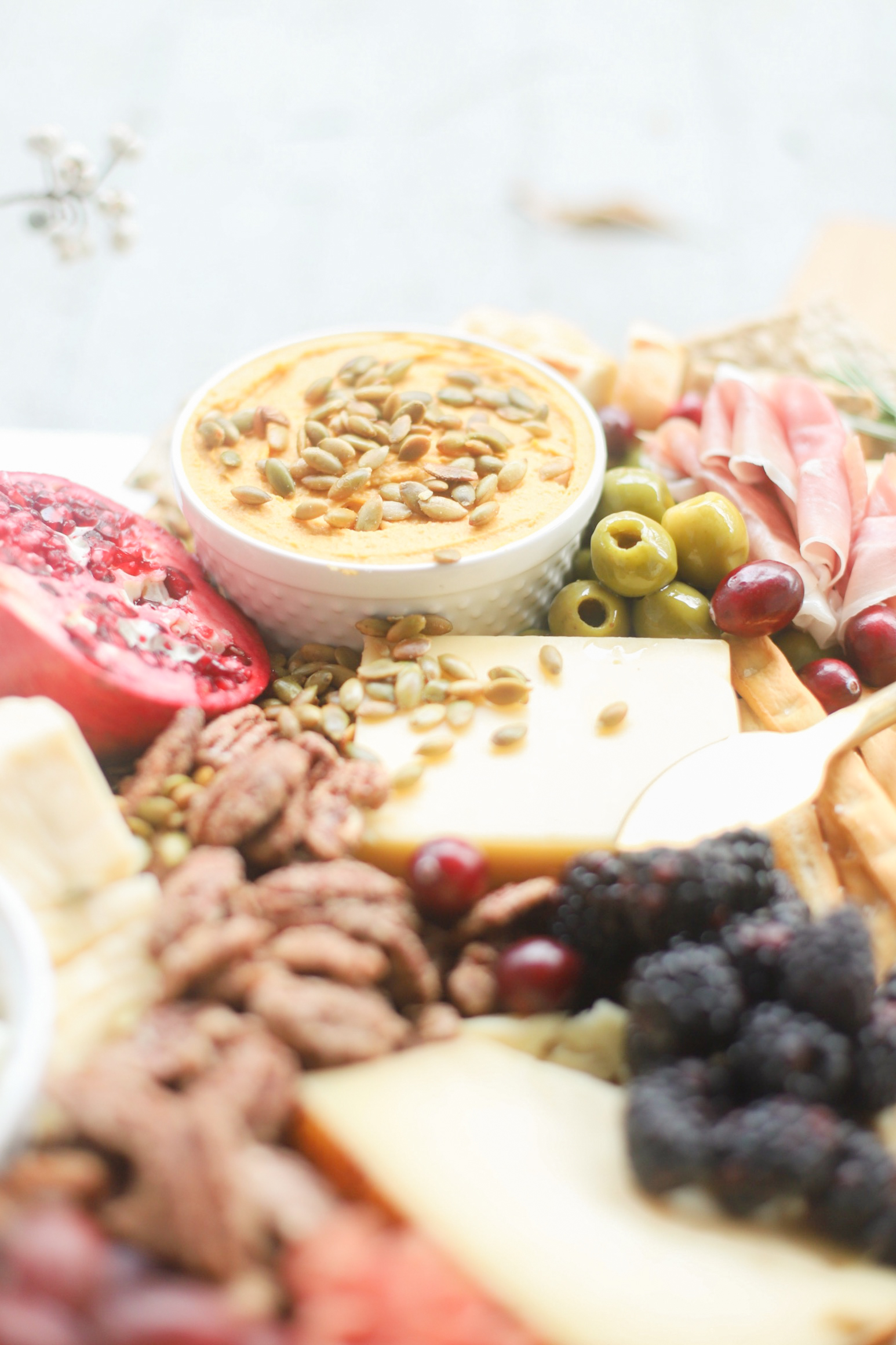 Putting together a big, beautiful charcuterie board is easier than you think. Make this impressive Thanksgiving cheese board for the fall holiday this year and seriously wow all of your guests! | glitterinc.com | @glitterinc