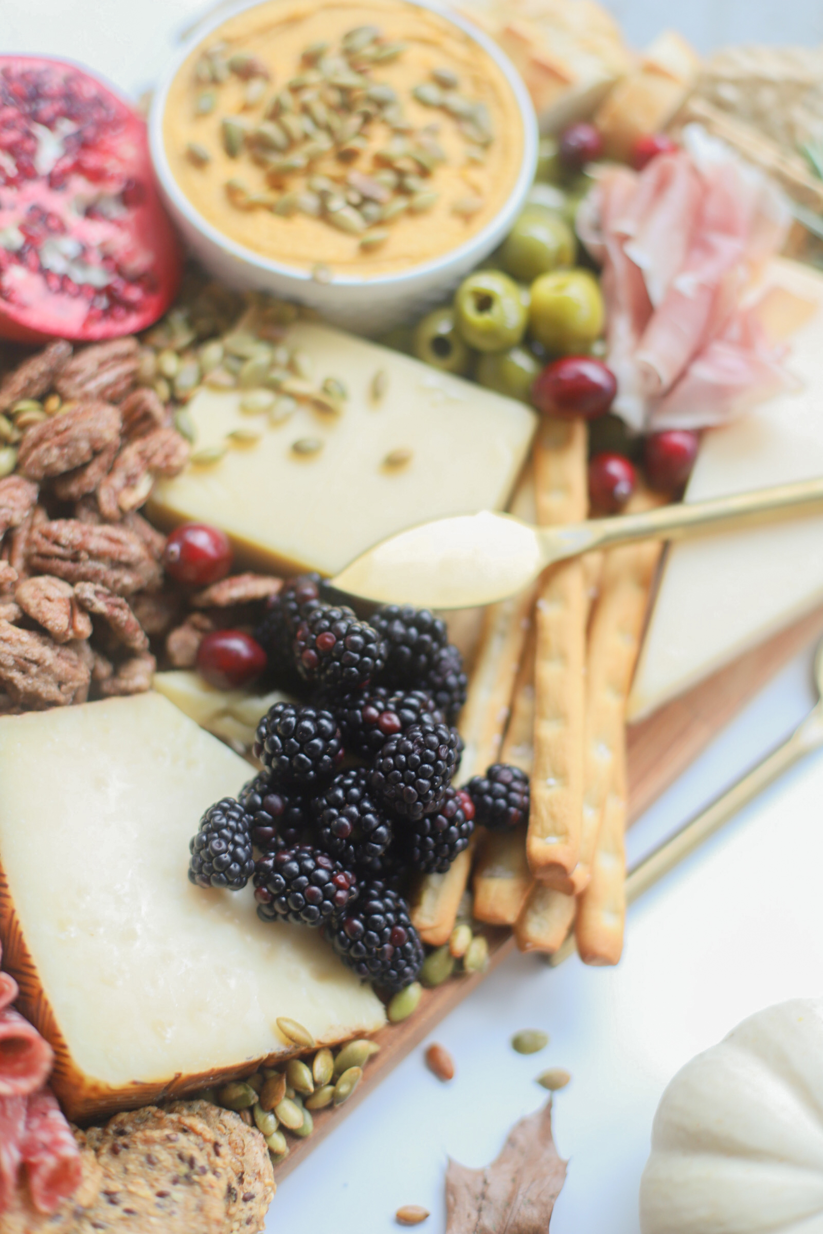 Putting together a big, beautiful charcuterie board is easier than you think. Make this impressive Thanksgiving cheese board for the fall holiday this year and seriously wow all of your guests! | glitterinc.com | @glitterinc