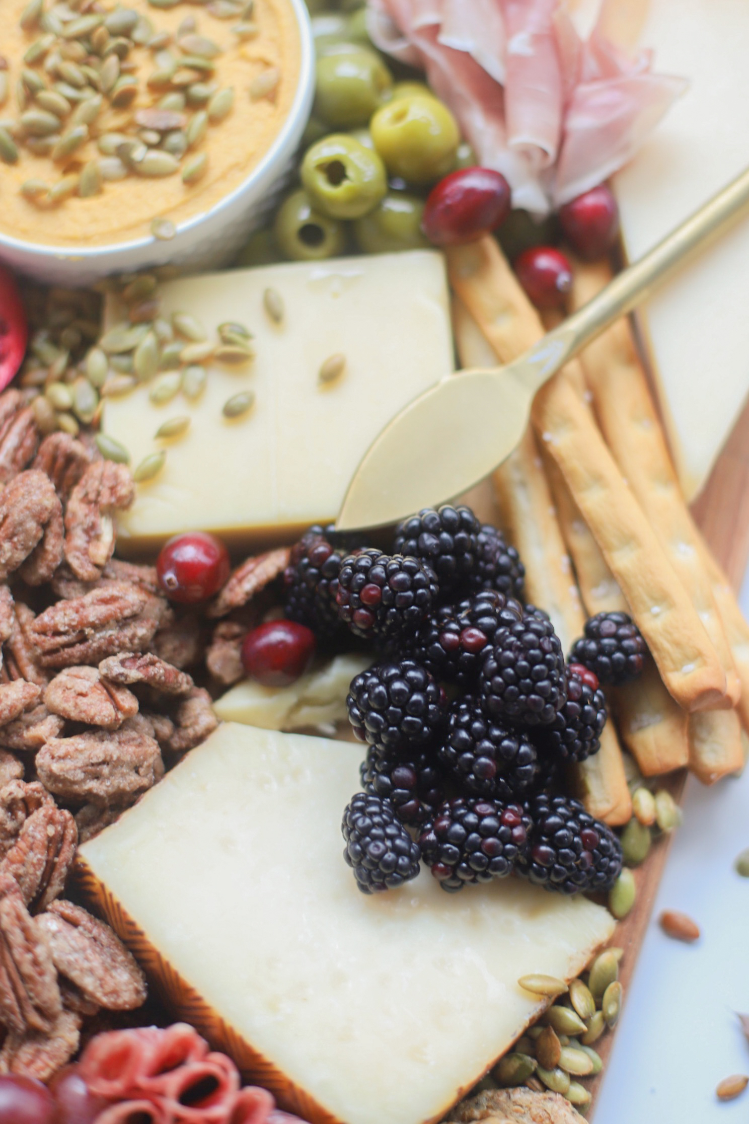 Putting together a big, beautiful charcuterie board is easier than you think. Make this impressive Thanksgiving cheese board for the fall holiday this year and seriously wow all of your guests! | glitterinc.com | @glitterinc