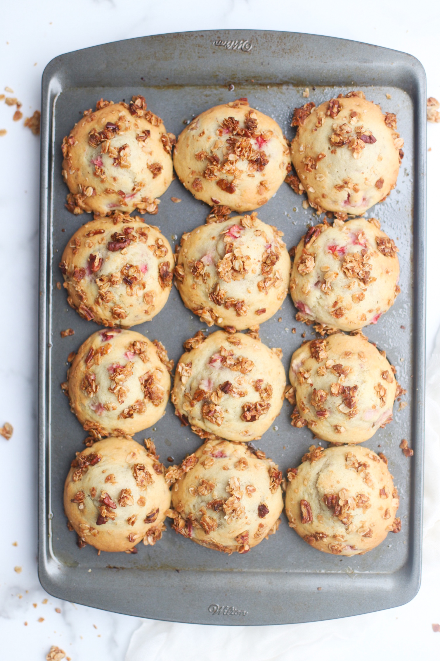 Bake up a batch of these decadently fluffy and moist bakery-style Strawberry Yogurt Granola Crumble Muffins, made with rich Greek yogurt, full of fresh strawberry flavor, and topped with our favorite homemade classic granola crumble. Click through for the recipe. | glitterinc.com | @glitterinc