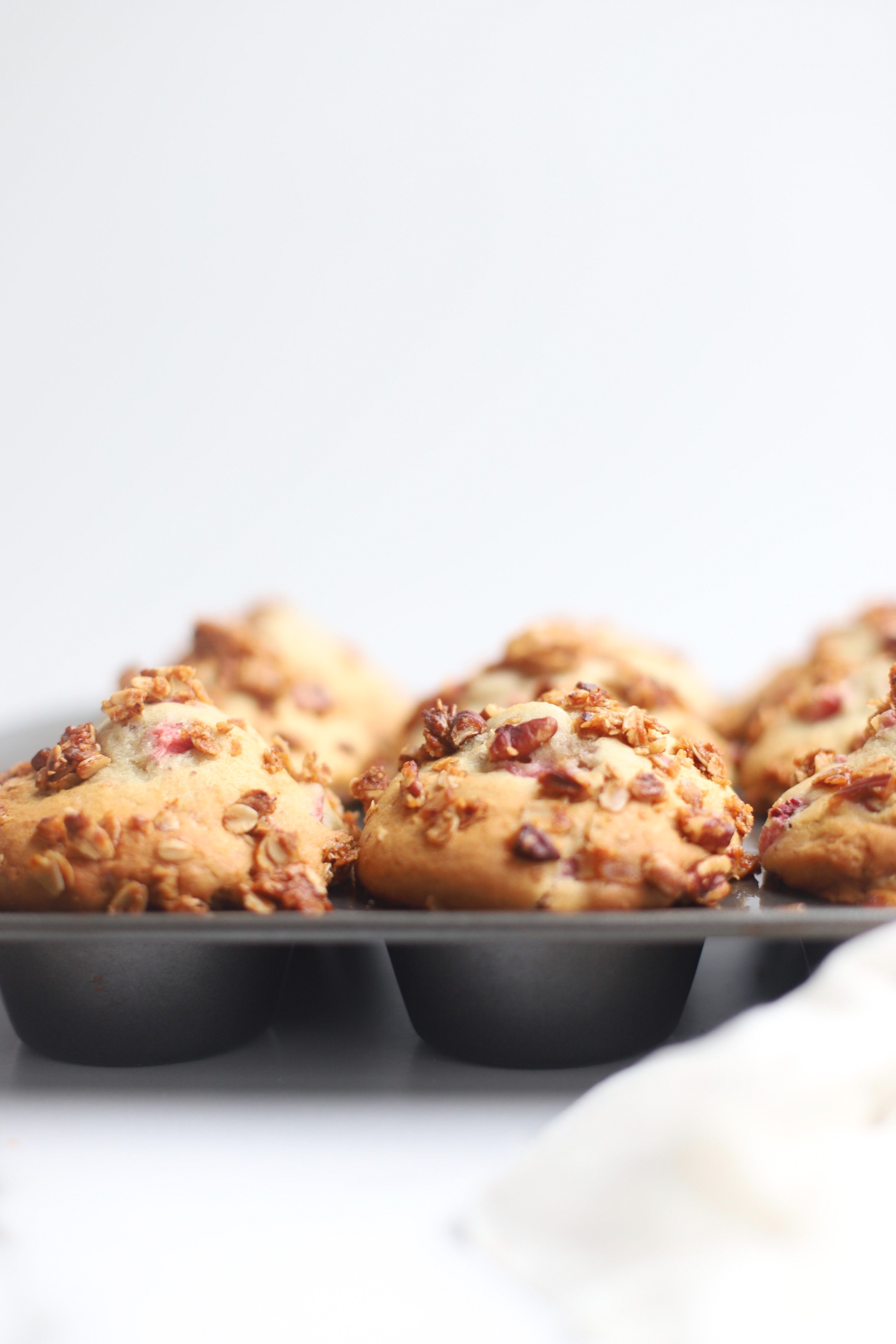 Bake up a batch of these decadently fluffy and moist bakery-style Strawberry Yogurt Granola Crumble Muffins, made with rich Greek yogurt, full of fresh strawberry flavor, and topped with our favorite homemade classic granola crumble. Click through for the recipe. | glitterinc.com | @glitterinc