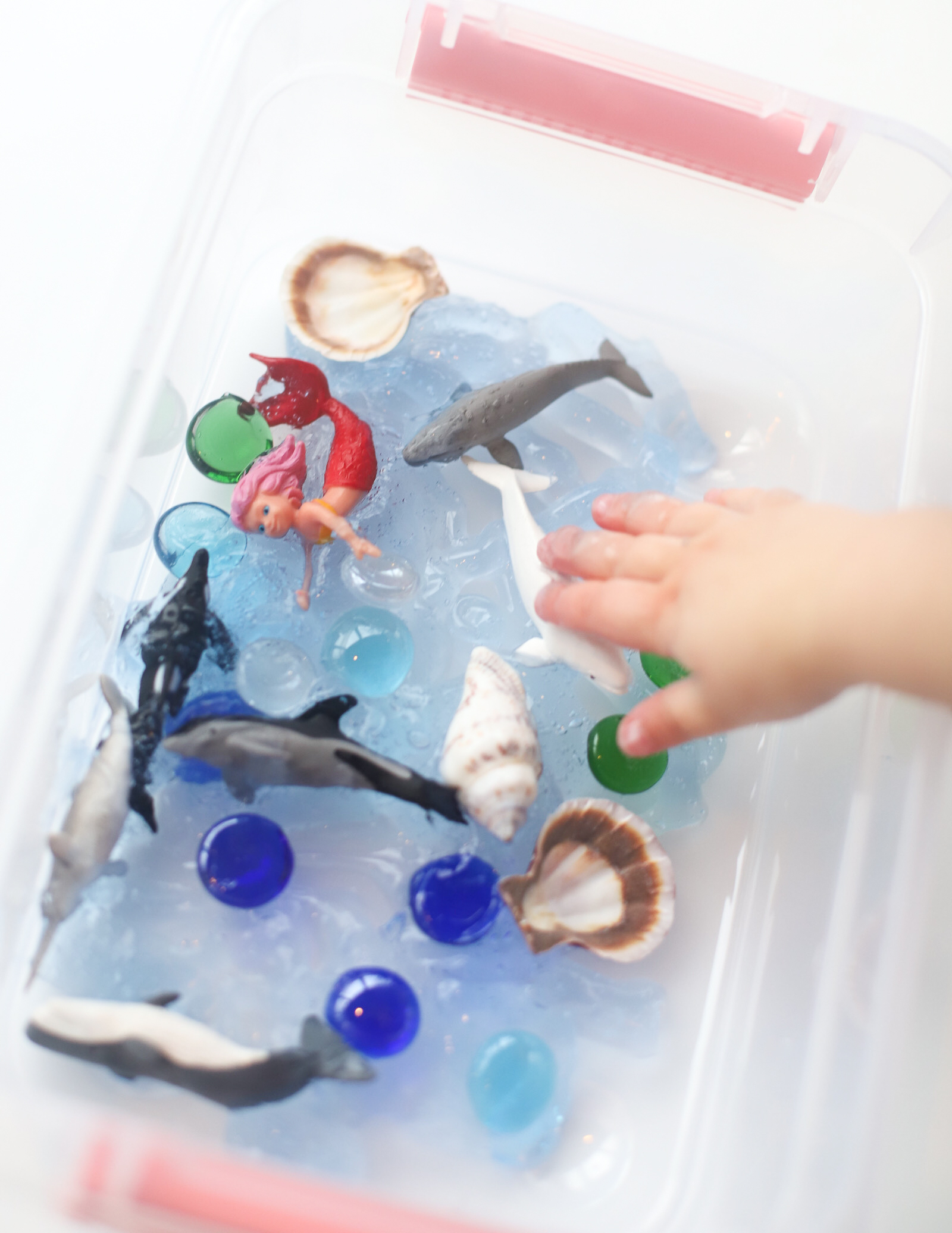 Make your kids an Easy and Fun Kids Ocean Sensory Bin Activity with inexpensive items and watch their imaginations run wild! Plus, a no mess option, and how to store and re-use the DIY ocean sensory bin again and again. This craft is a perfect learning activity for toddlers, preschools, kindergarteners, and beyond! | glitterinc.com | @glitterinc