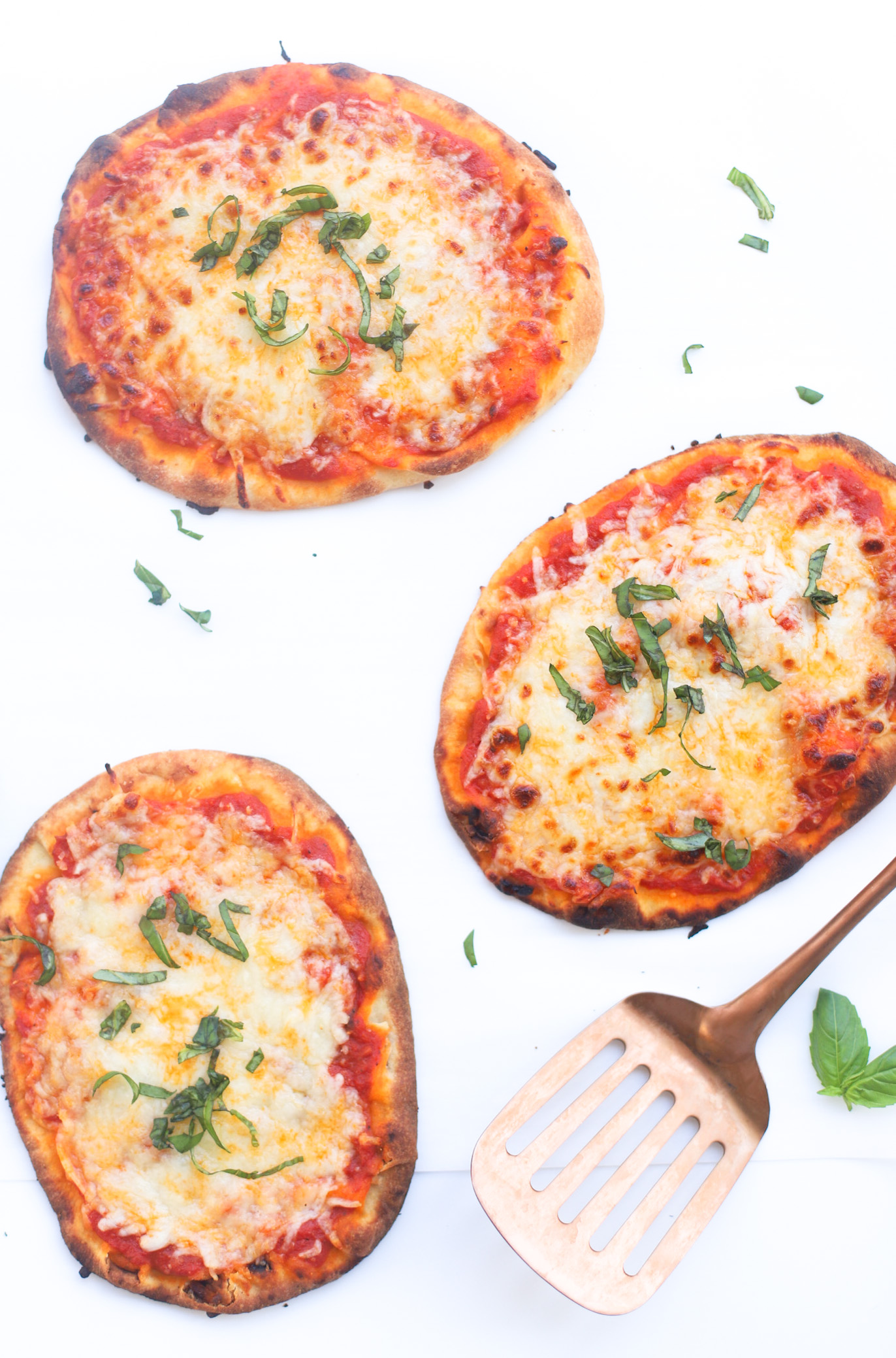 Our Favorite 10-Minute Naan Bread Pizza recipe bakes up with a crispy, golden crust, is topped with tomato sauce and bubbly cheese, and is so easy to make. The whole family loves making and eating these delicious simple at-home pizzas for lunch and dinner! | glitterinc.com | @glitterinc