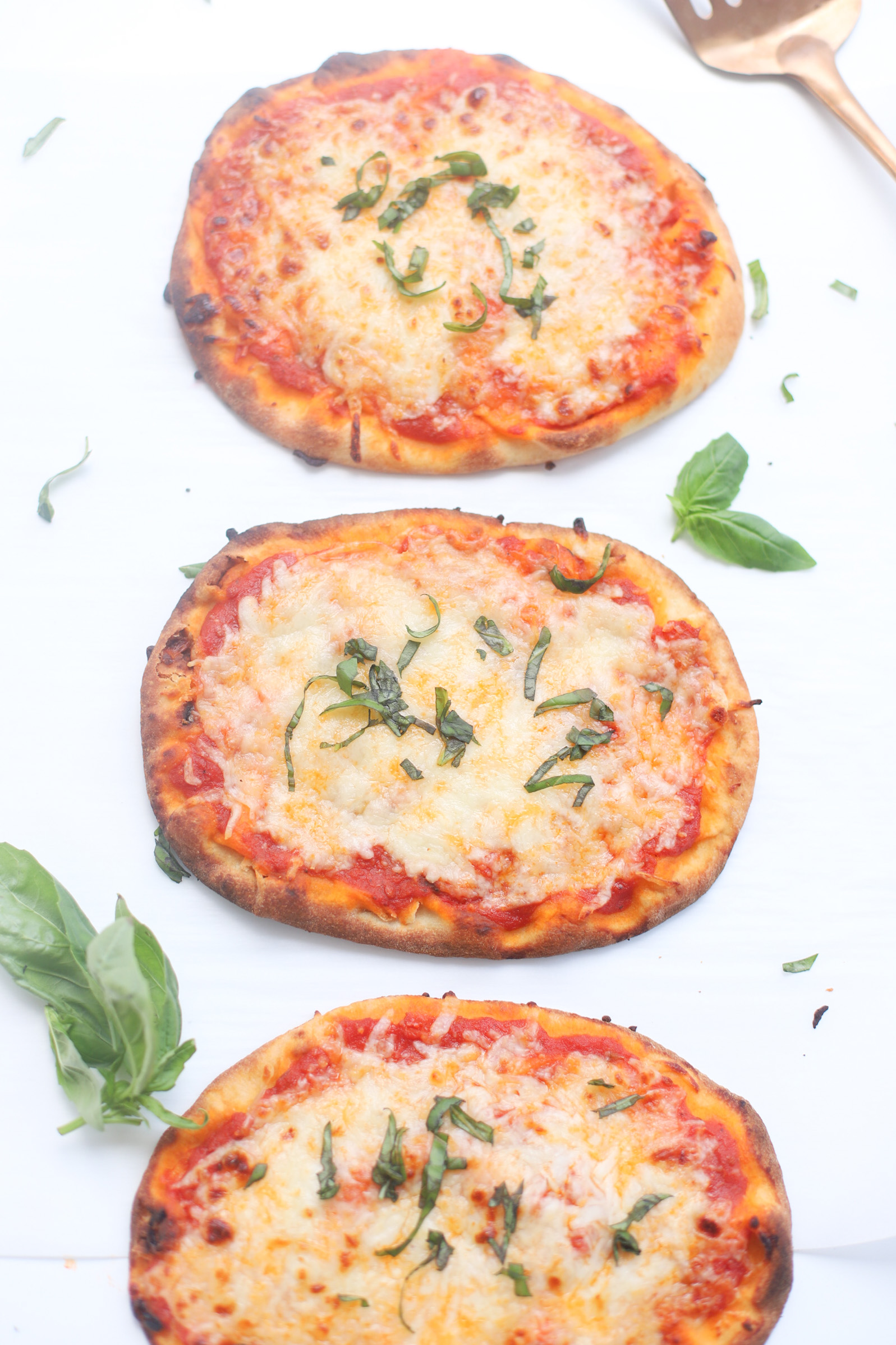 Our Favorite 10-Minute Naan Bread Pizza recipe bakes up with a crispy, golden crust, is topped with tomato sauce and bubbly cheese, and is so easy to make. The whole family loves making and eating these delicious simple at-home pizzas for lunch and dinner! | glitterinc.com | @glitterinc