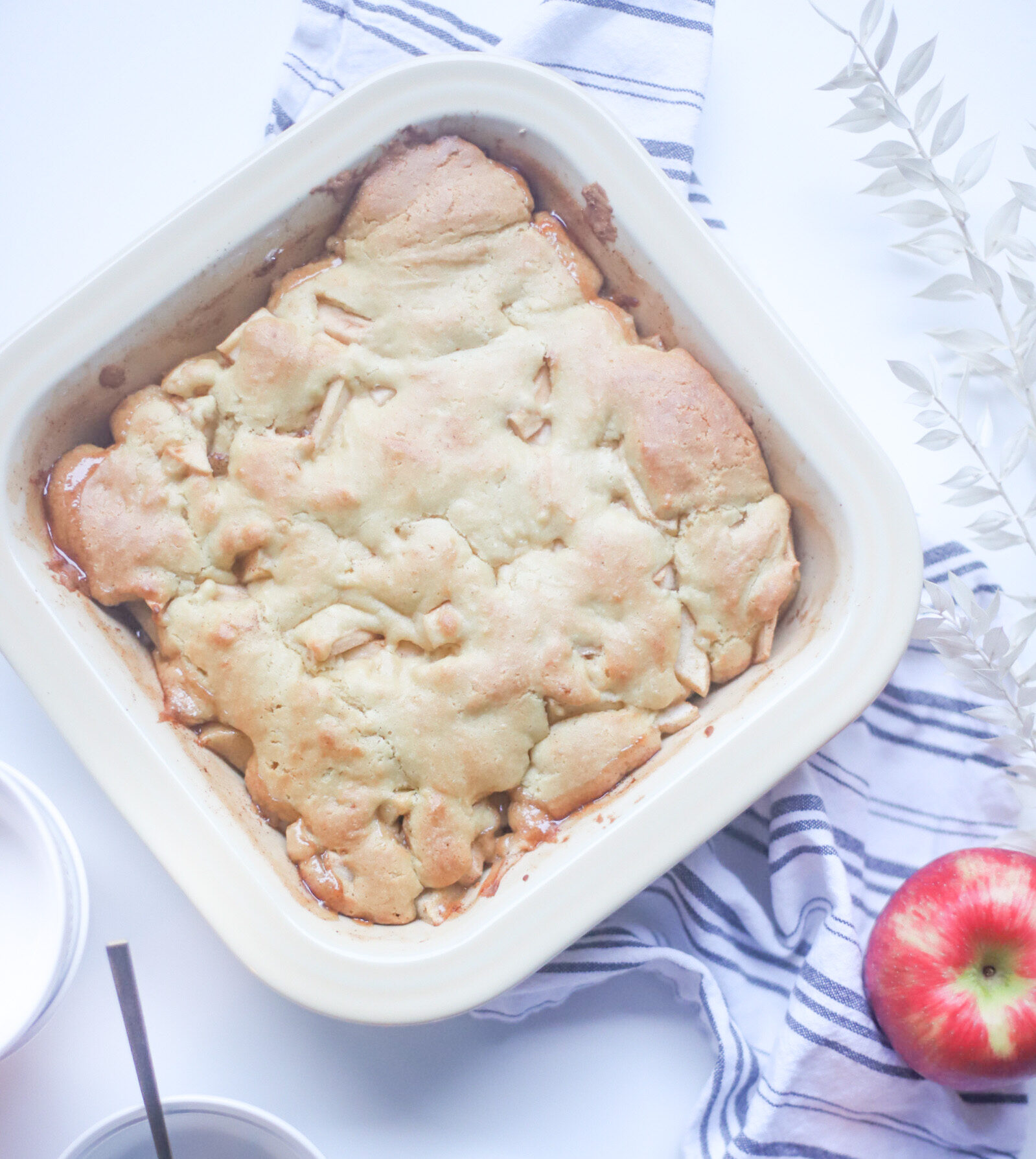 This deceptively delicious apple cobbler is full of cinnamon, fragrant apples, and a velvety caramel sauce, topped with the most heavenly dough, and yet, is actually lower calorie than a traditional cobbler and can also be made dairy-free! Click through for the fall recipe. | @glitterinclexi | GLITTERINC.COM