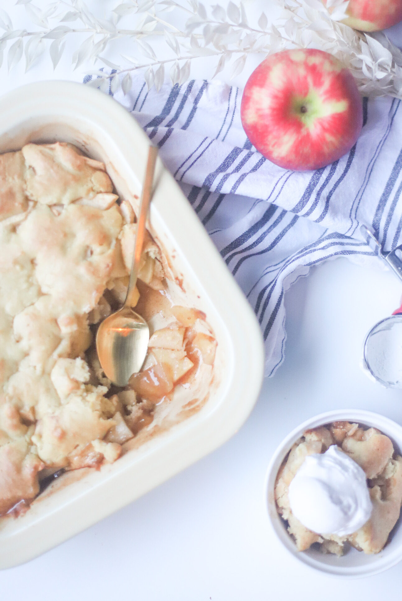 This deceptively delicious apple cobbler is full of cinnamon, fragrant apples, and a velvety caramel sauce, topped with the most heavenly dough, and yet, is actually lower calorie than a traditional cobbler and can also be made dairy-free! Click through for the fall recipe. | @glitterinclexi | GLITTERINC.COM