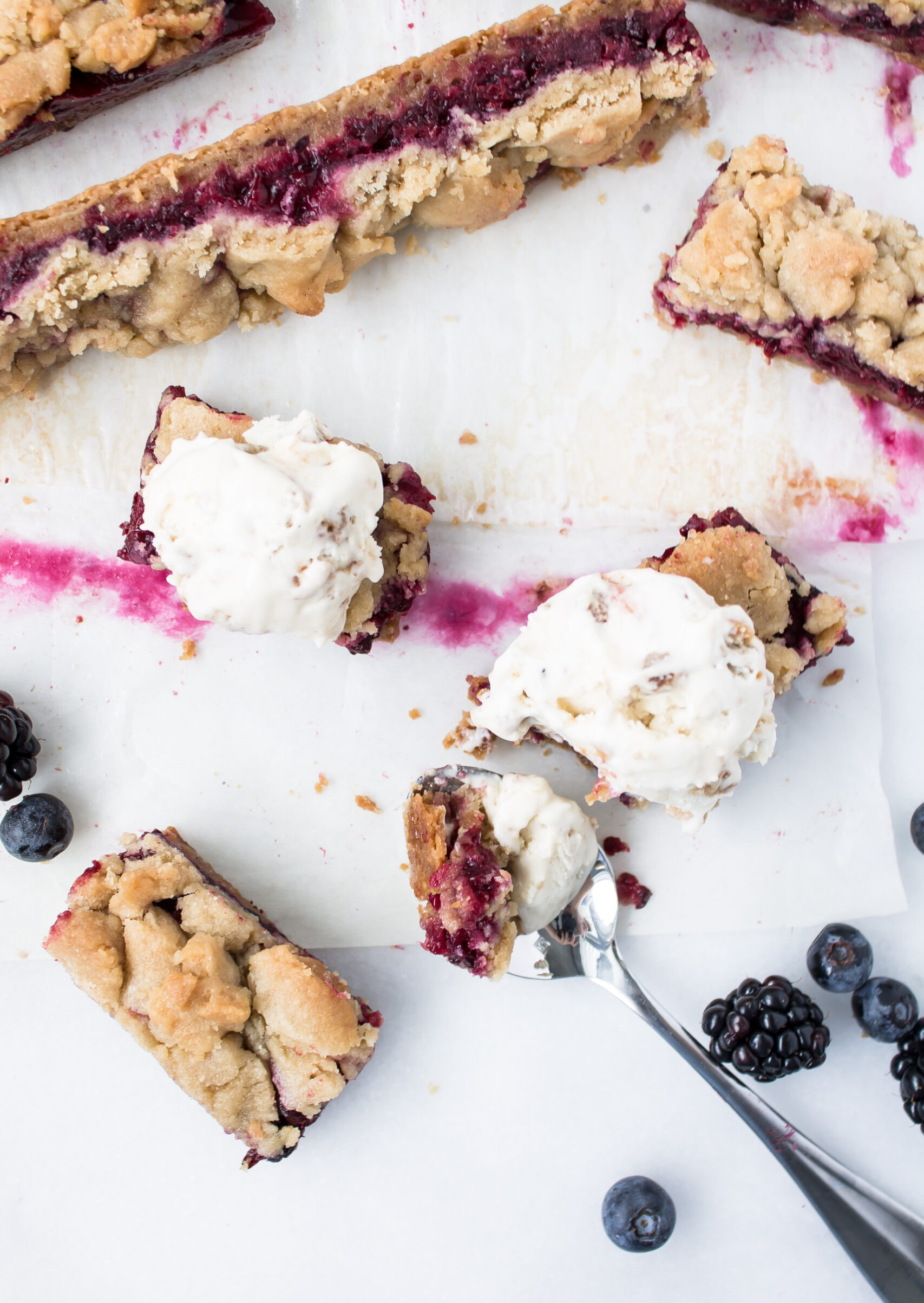 These blackberry and blueberry pie bars are basically a delightful crumb pie in bar form. The bars have a decadent shortbread base, a layer of sweet and jammy blueberries and blackberries, and a buttery, crumble topping. Perfect for a brunch or portable dessert for a party! | @glitterinclexi | GLITTERINC.COM