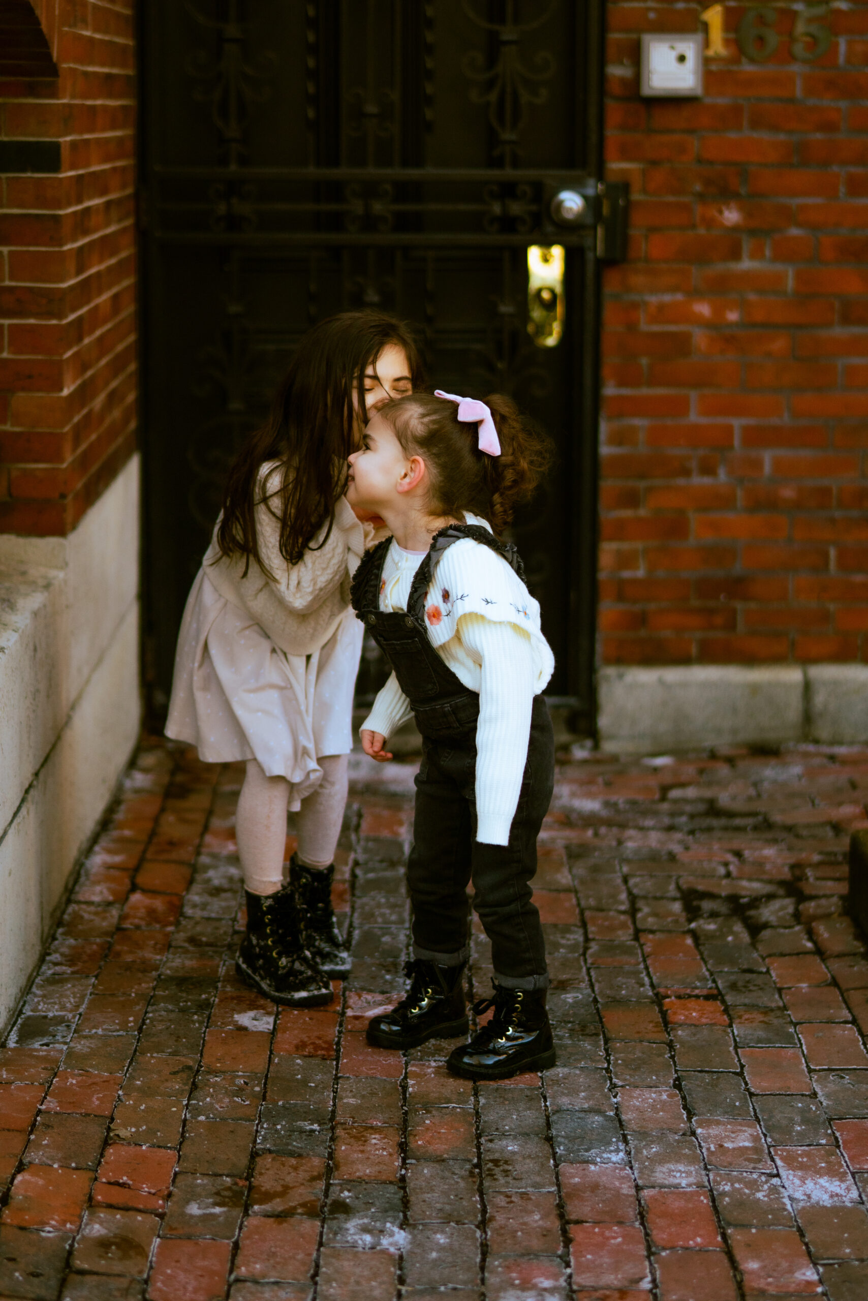 a little girl whispering to her sister