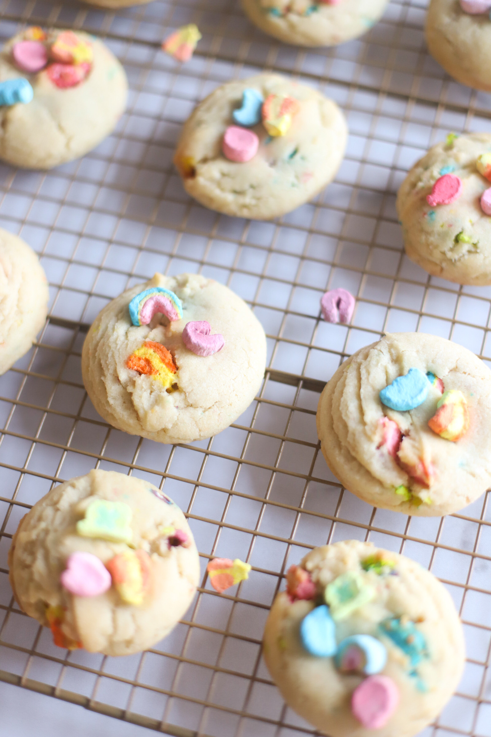 The best and most unbelievably perfect dairy free sugar cookies, filled and topped with Lucky Charms marshmallows, plus a soft, thick, and chewy interior; these festive pillowy sugar cookies are a deliciously adorable recipe for a St. Patrick’s Day treat. | @glitterinclexi | GLITTERINC.COM