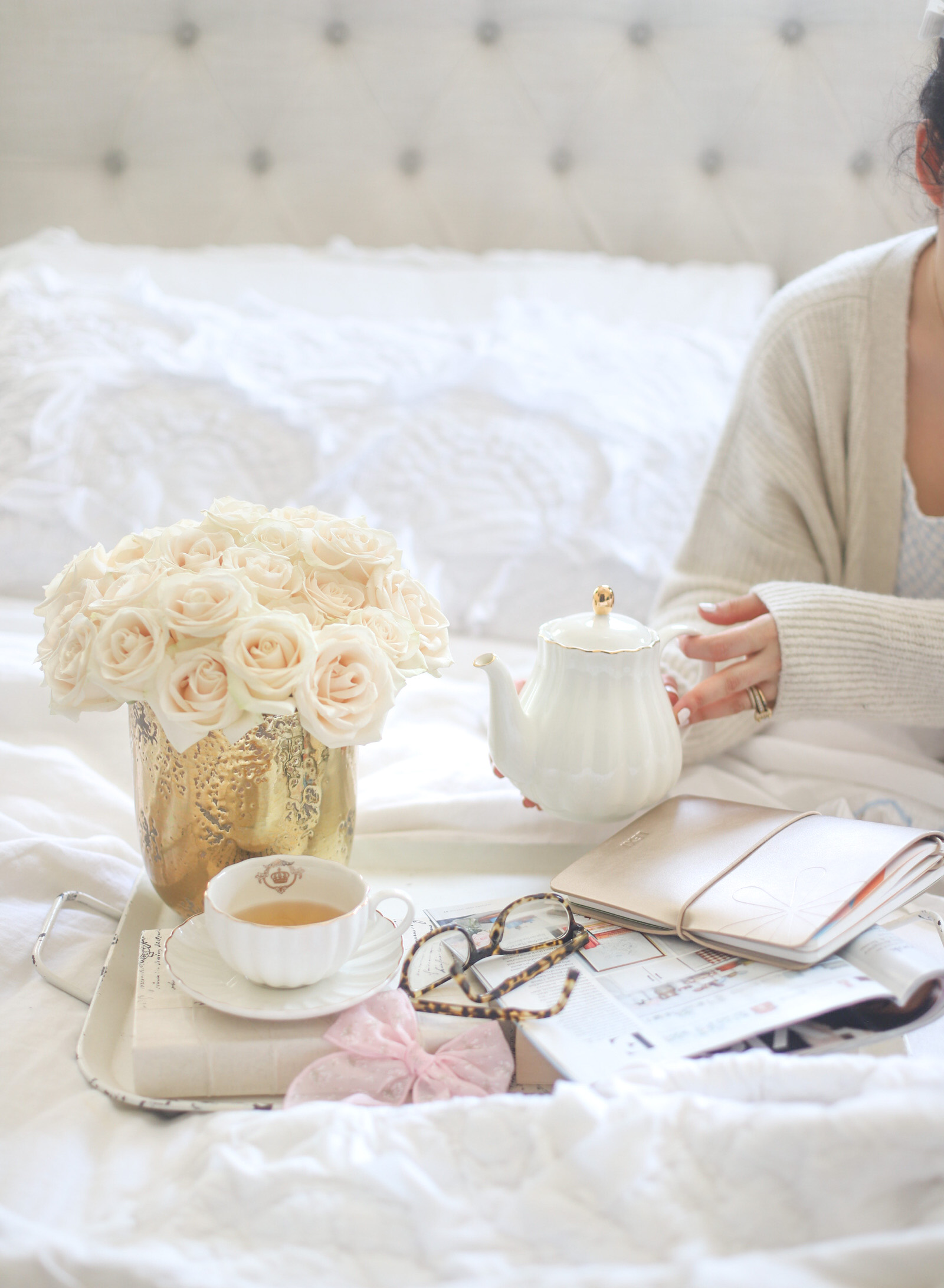 woman in bed with flowers and tea for vacation vibes 