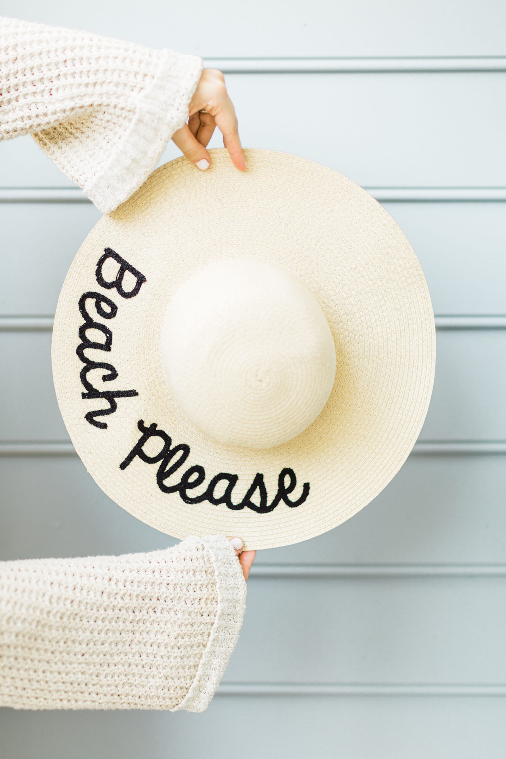 woman holding summer embroidered with beach please as one of the Best Summer Hats 