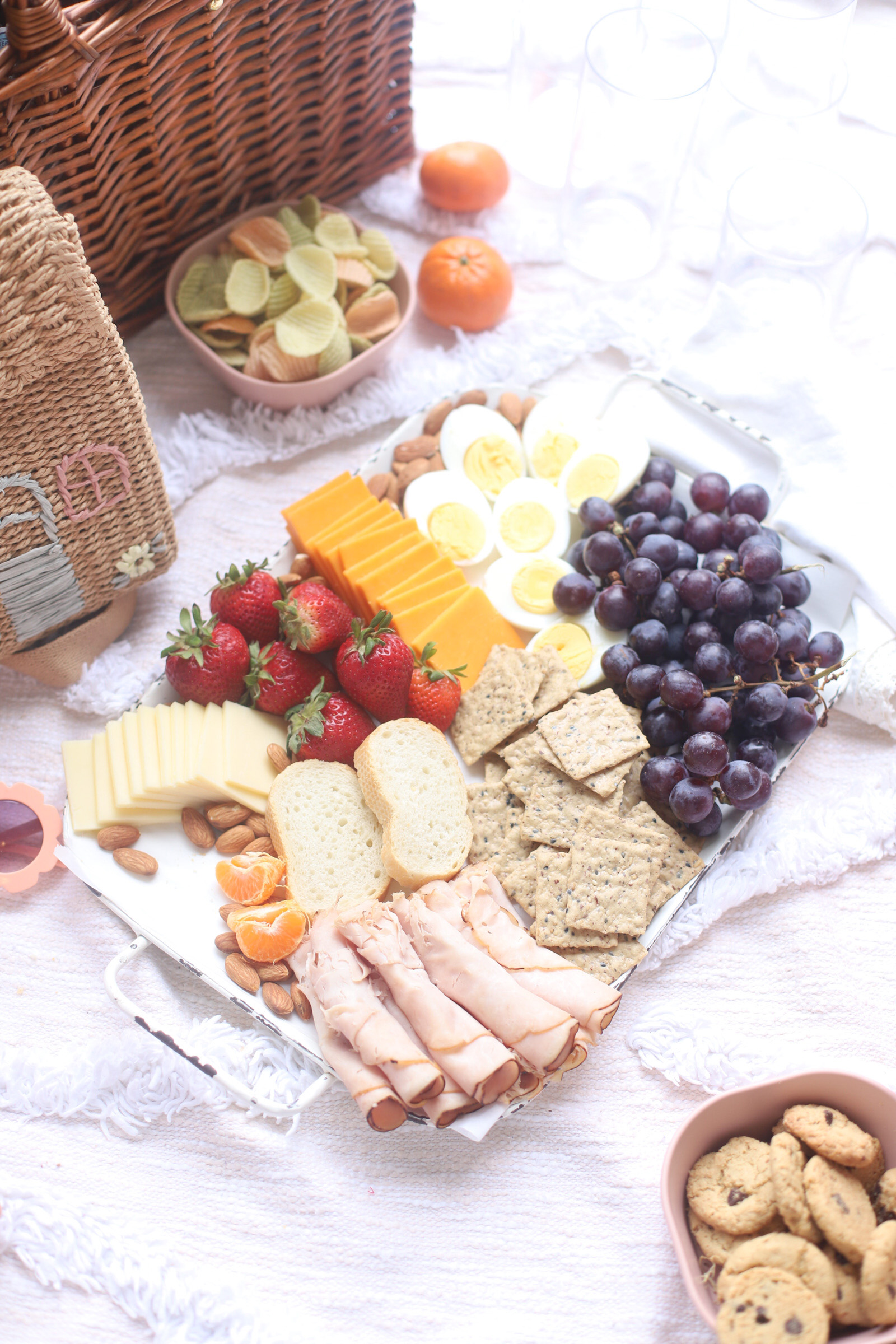 a charcuterie board with fruits, meat. crackers, cheese, and egg