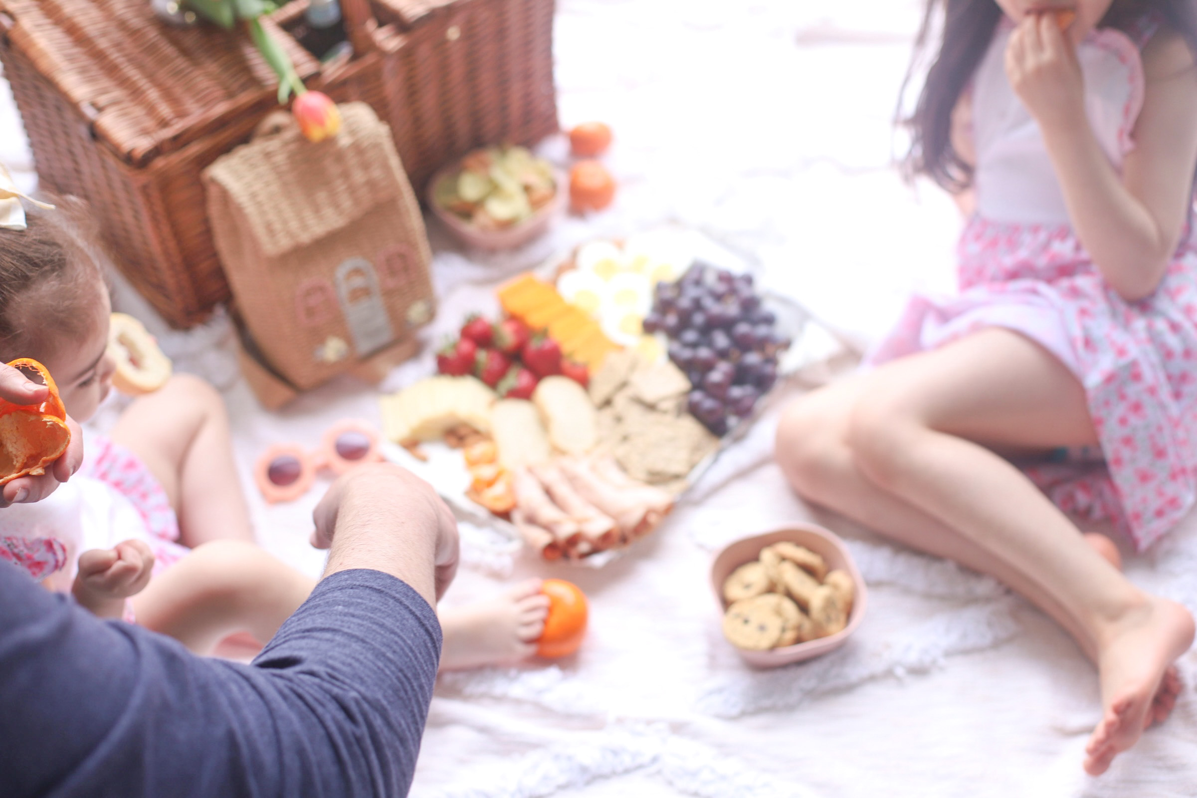 two kids, a picnic basket, and a charcuterie board