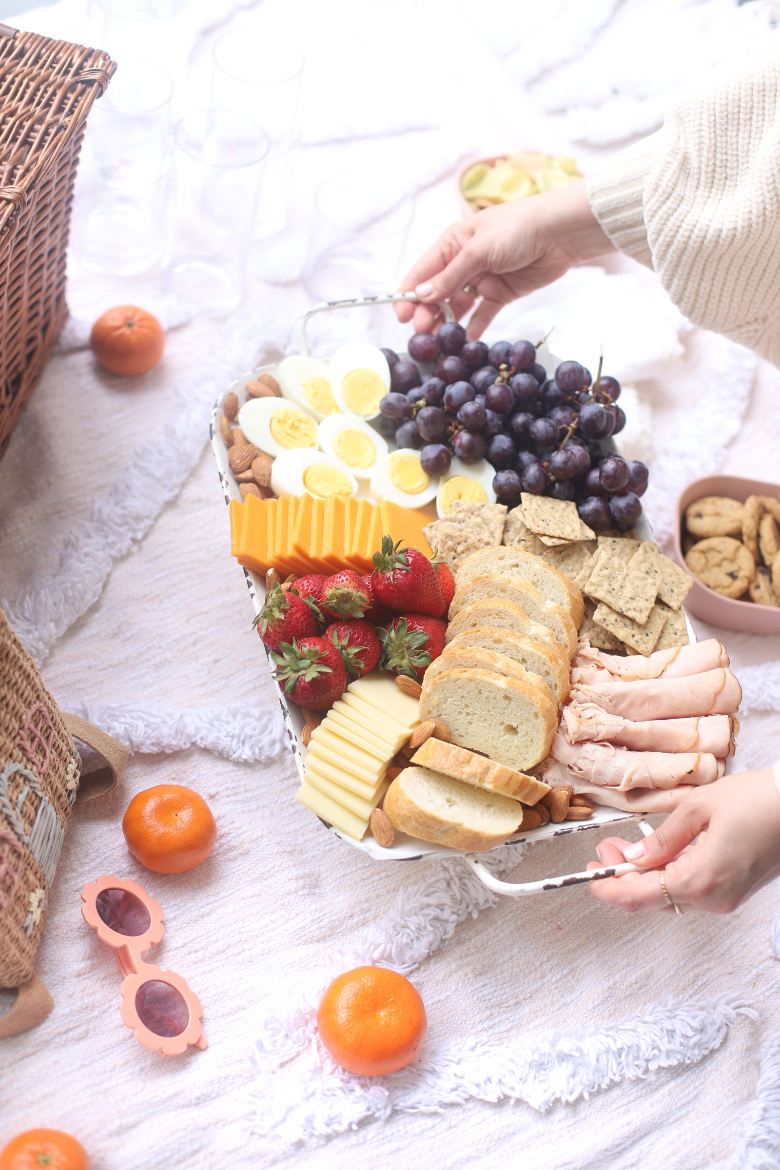 basket full of bread, eggs, fruits, and cheese for Charcuterie Board