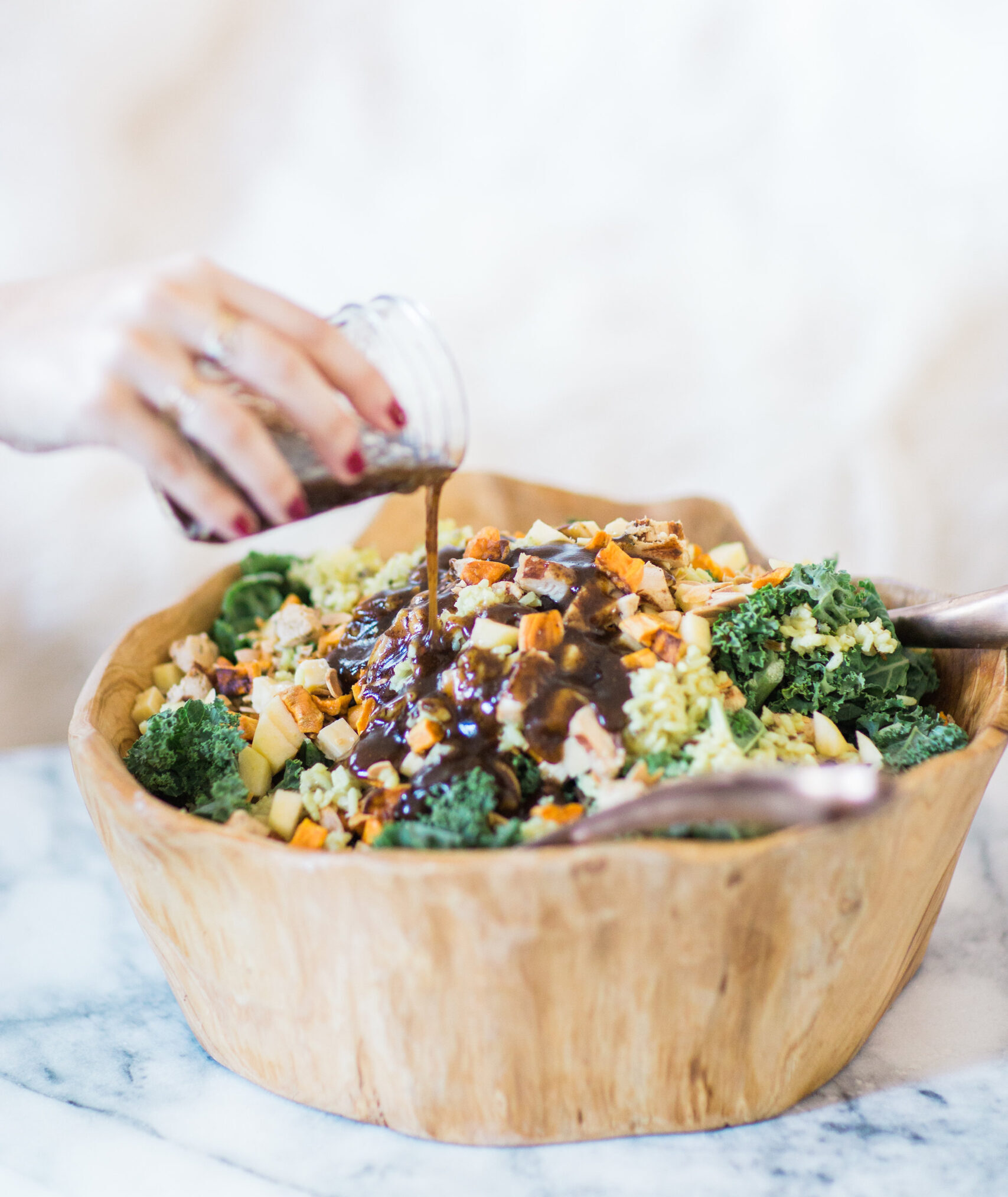 woman pouring sauce on homemade salad from Sweetgreen Harvest 