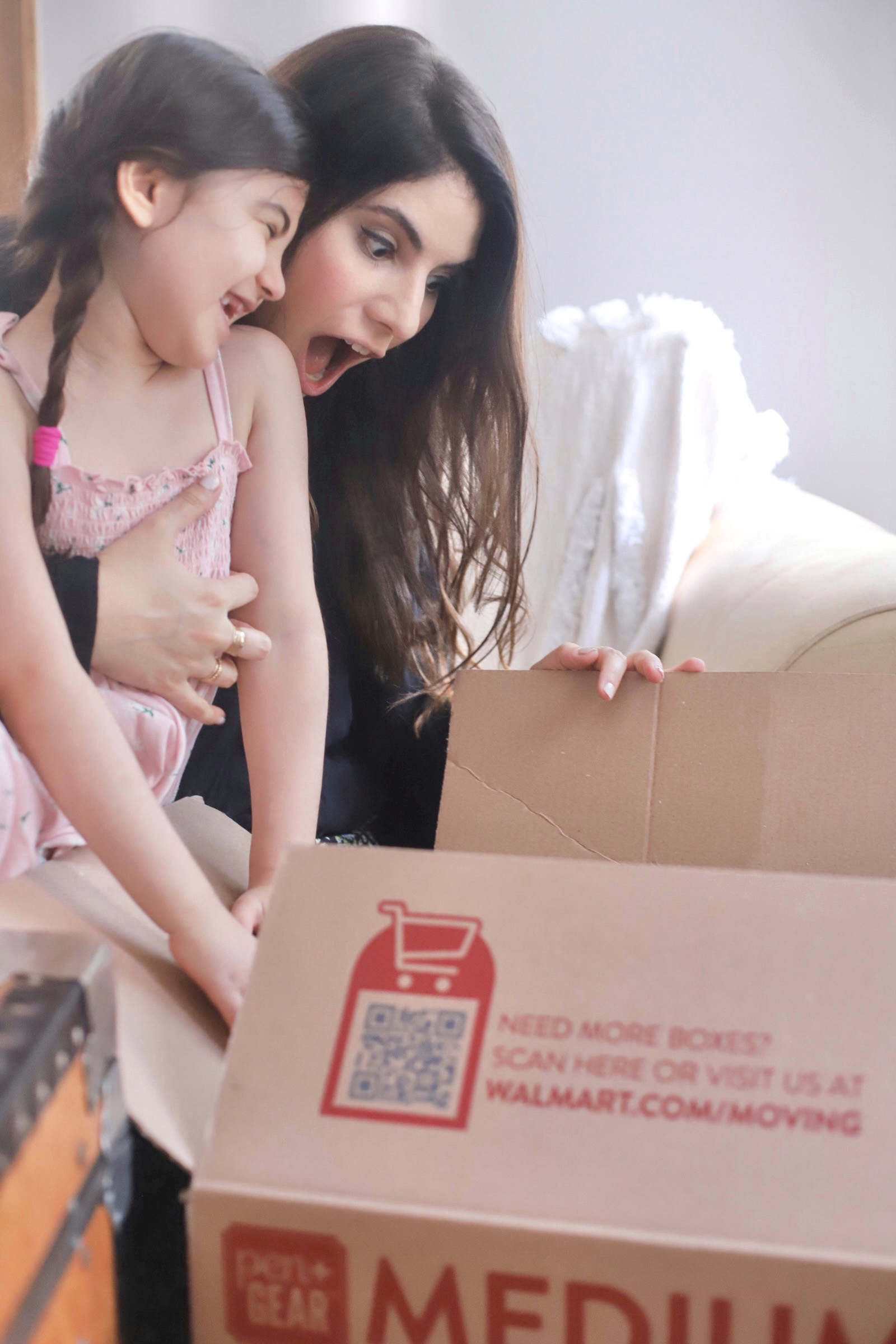 mother and daughter looking at a box in shock 