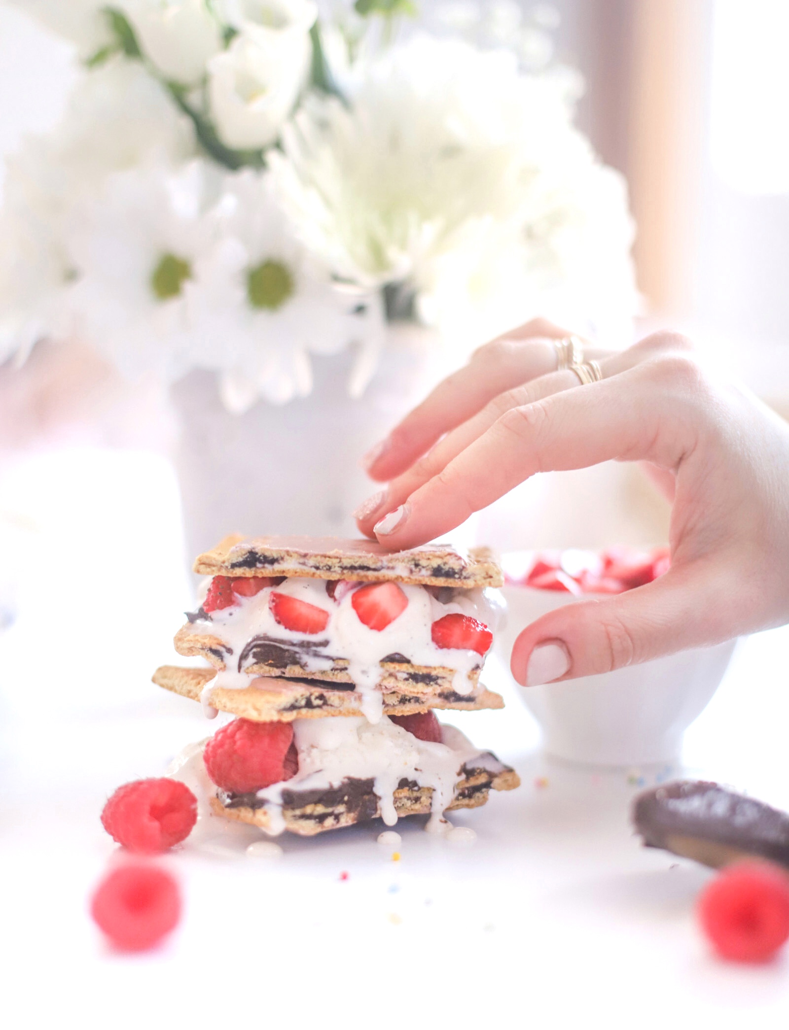 hand holding a dessert with berries and ice cream