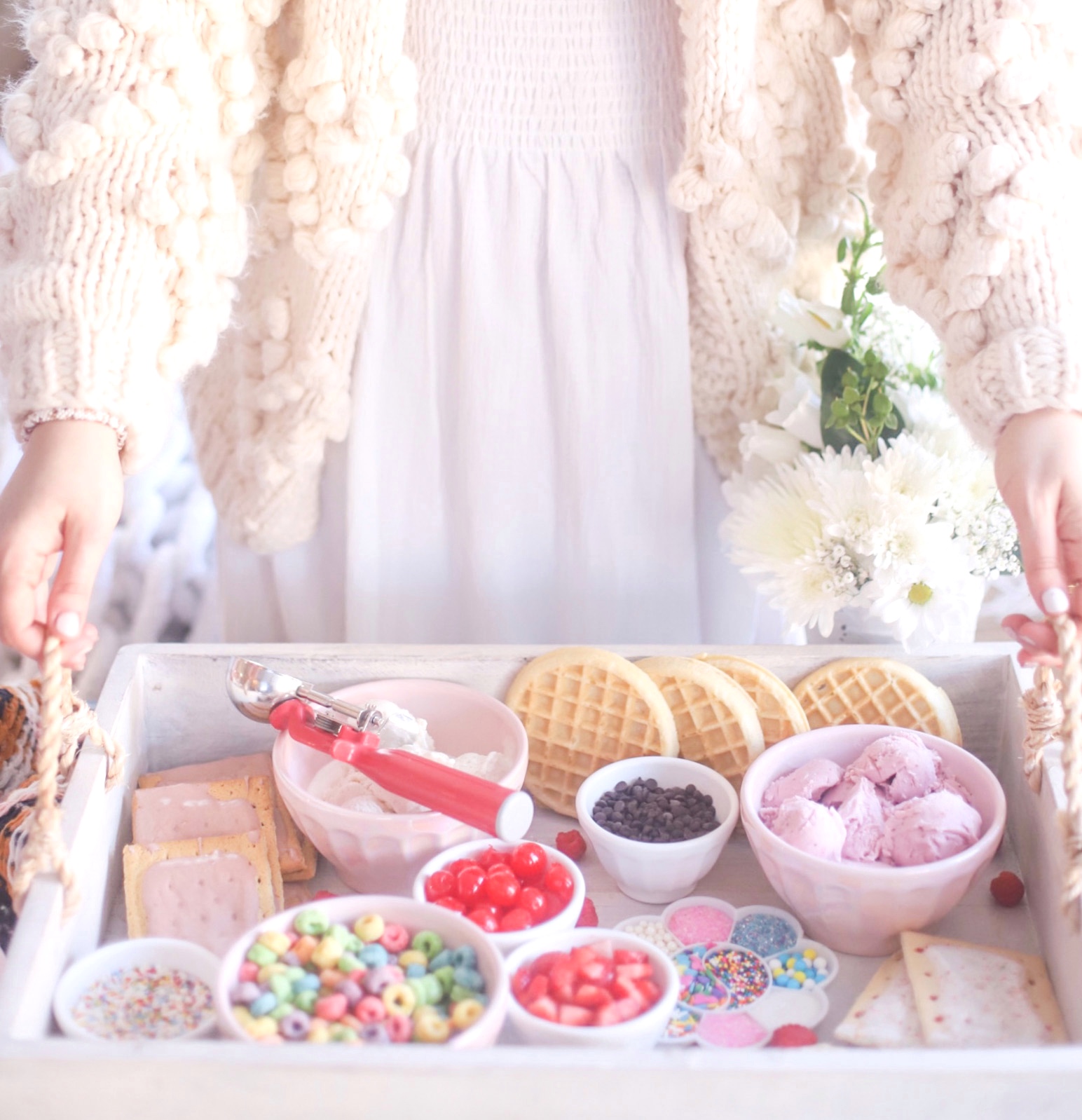 woman holding a tray with Create-Your-Own Ice Cream and toppings