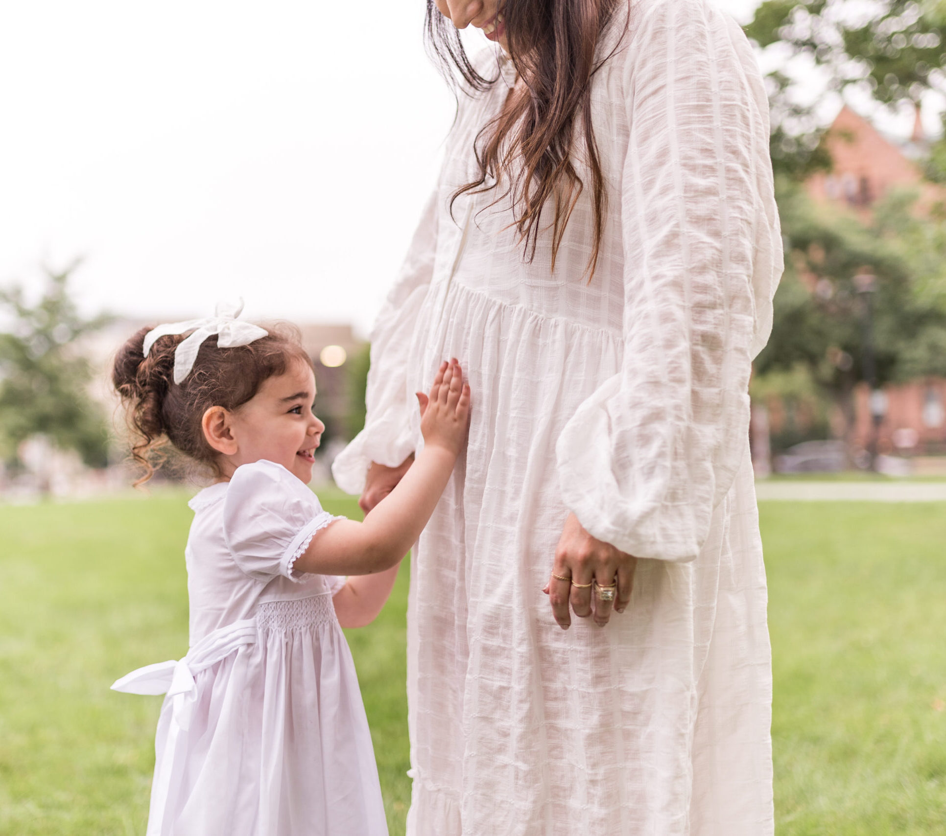 child touching her mother's baby bump