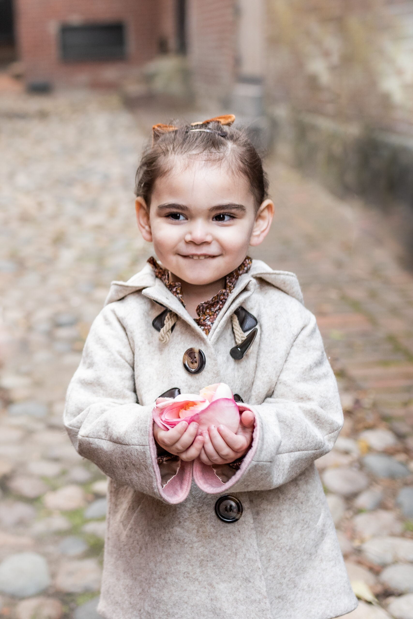 child holding a pink flower 