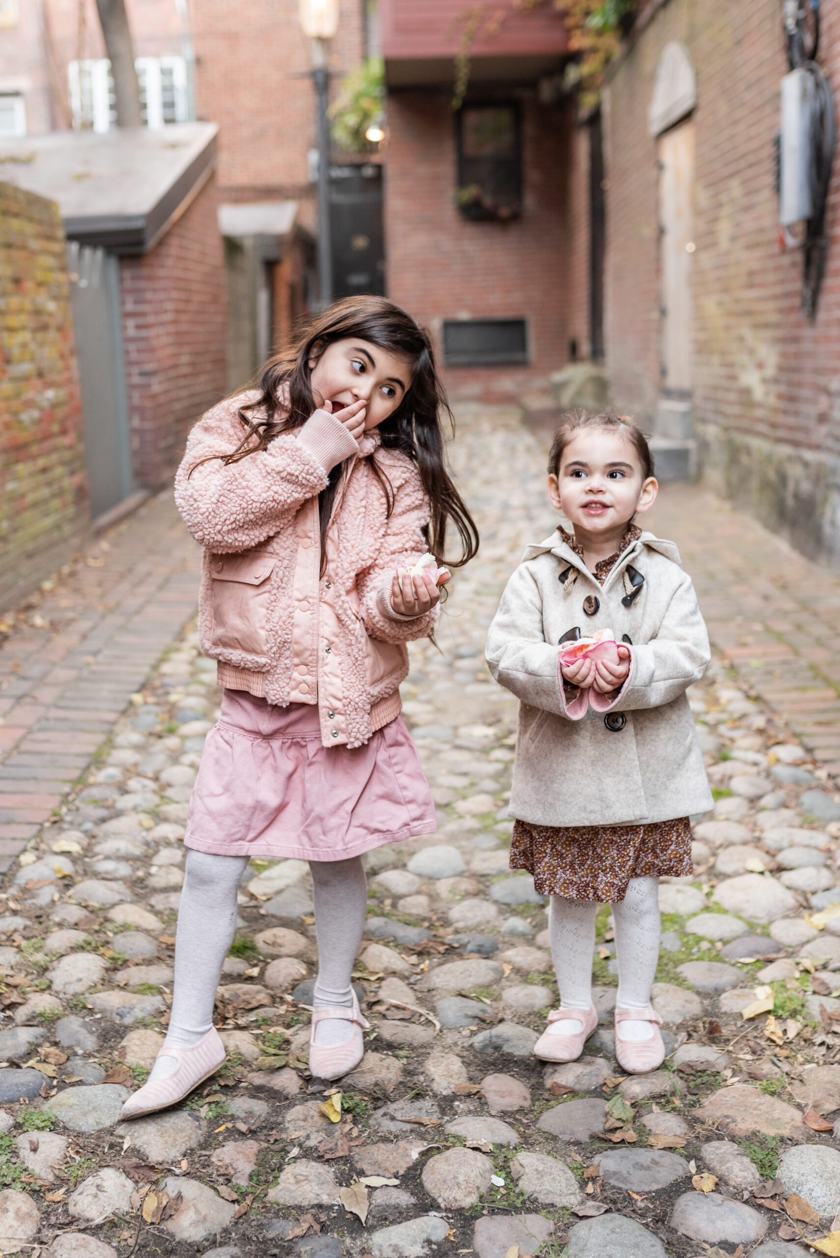 two kids holding pink flowers sharing Baby Number 3 Gender Reveal Announcement