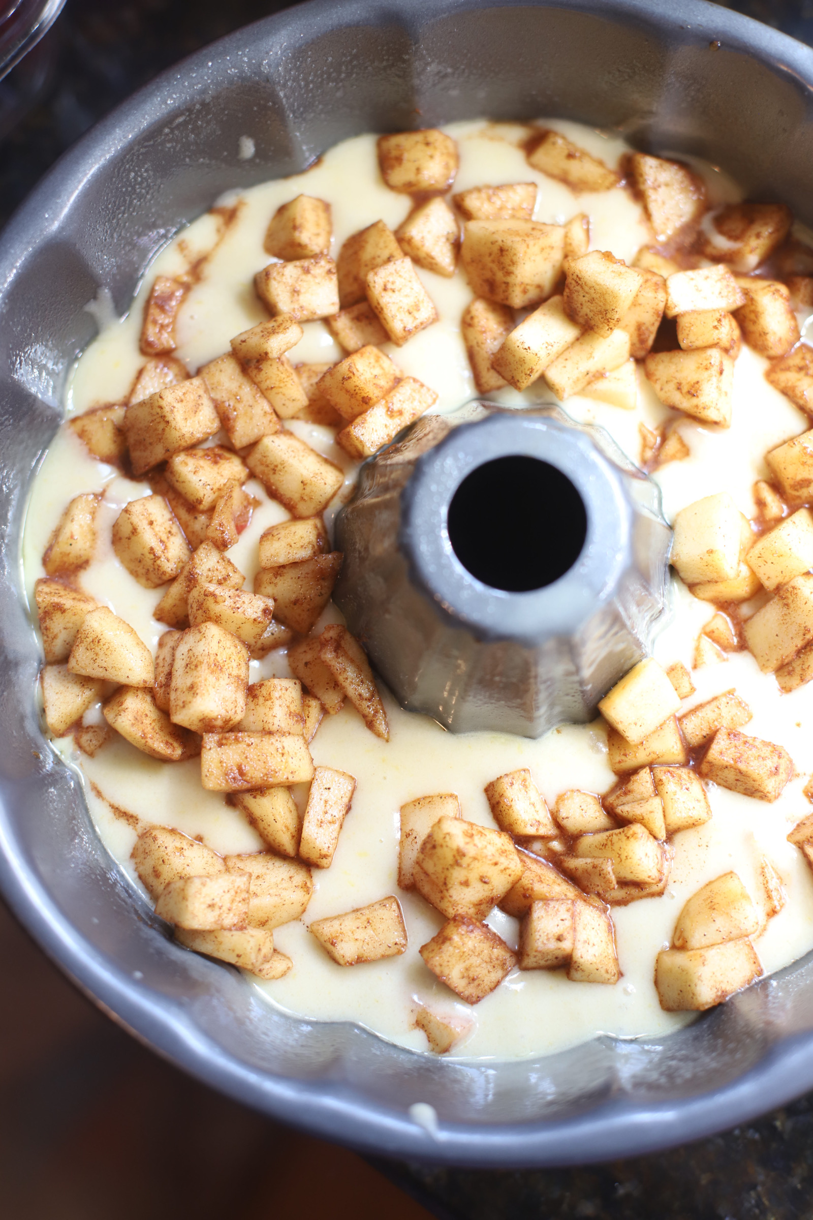 apple slices in a baking pan with milk for classic apple cake 